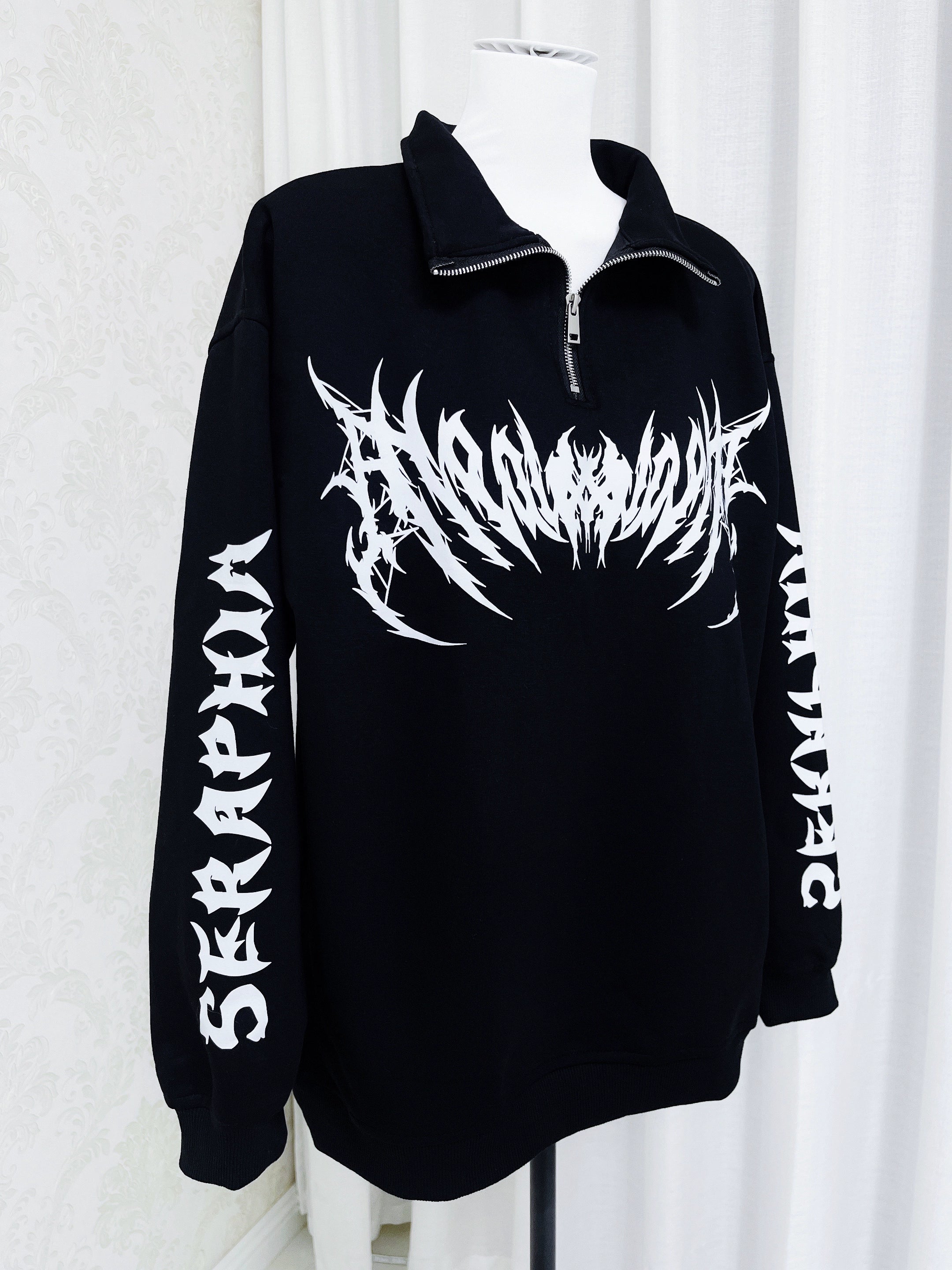 Gothic black sweatshirt quarter-zip collar detail on mannequin, displaying loose fit and long sleeve construction with white graphic elements