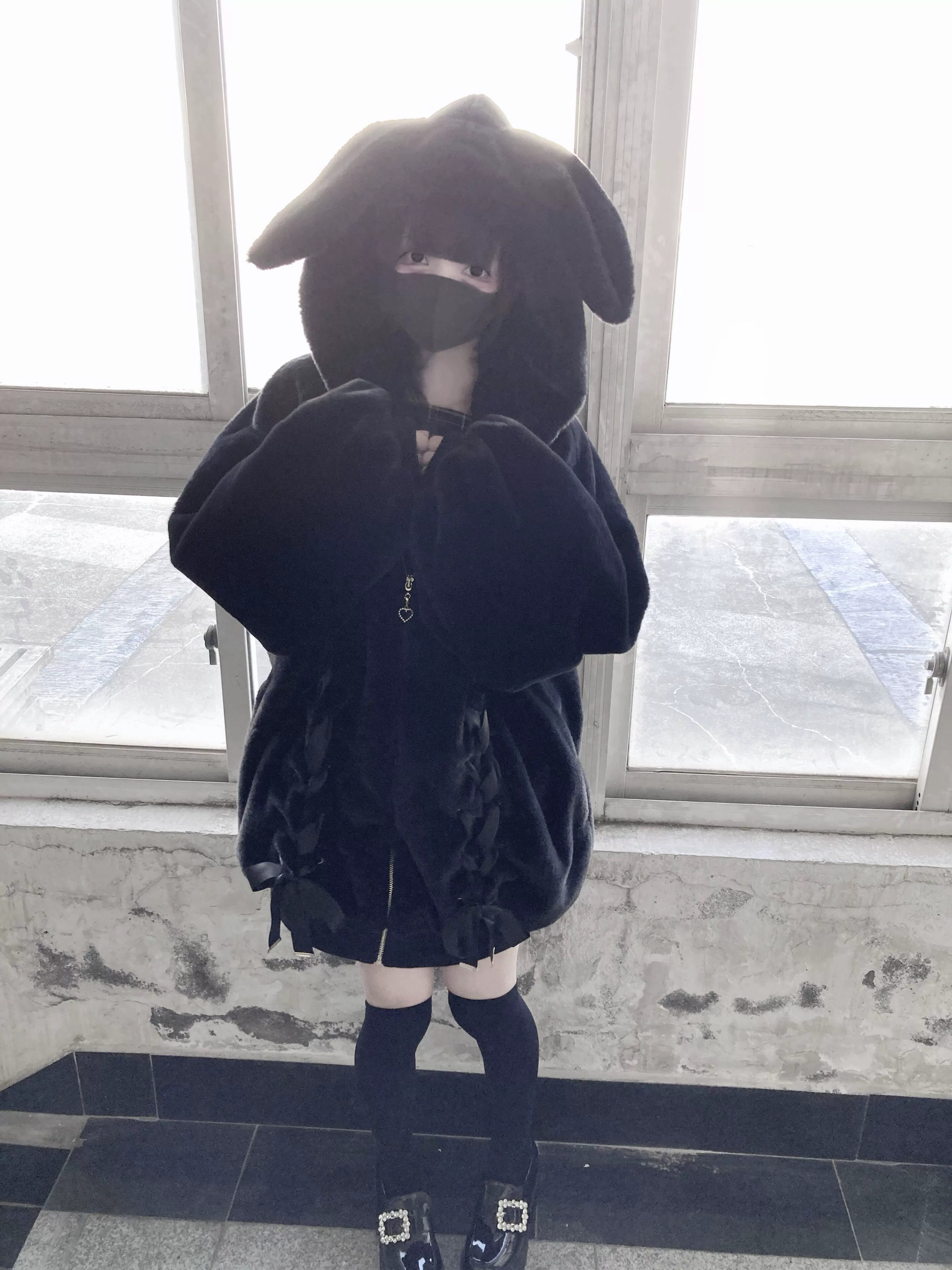 Full bunny ear hood close-up on black plush fleece coat showing oversized hood and fuzzy texture detail