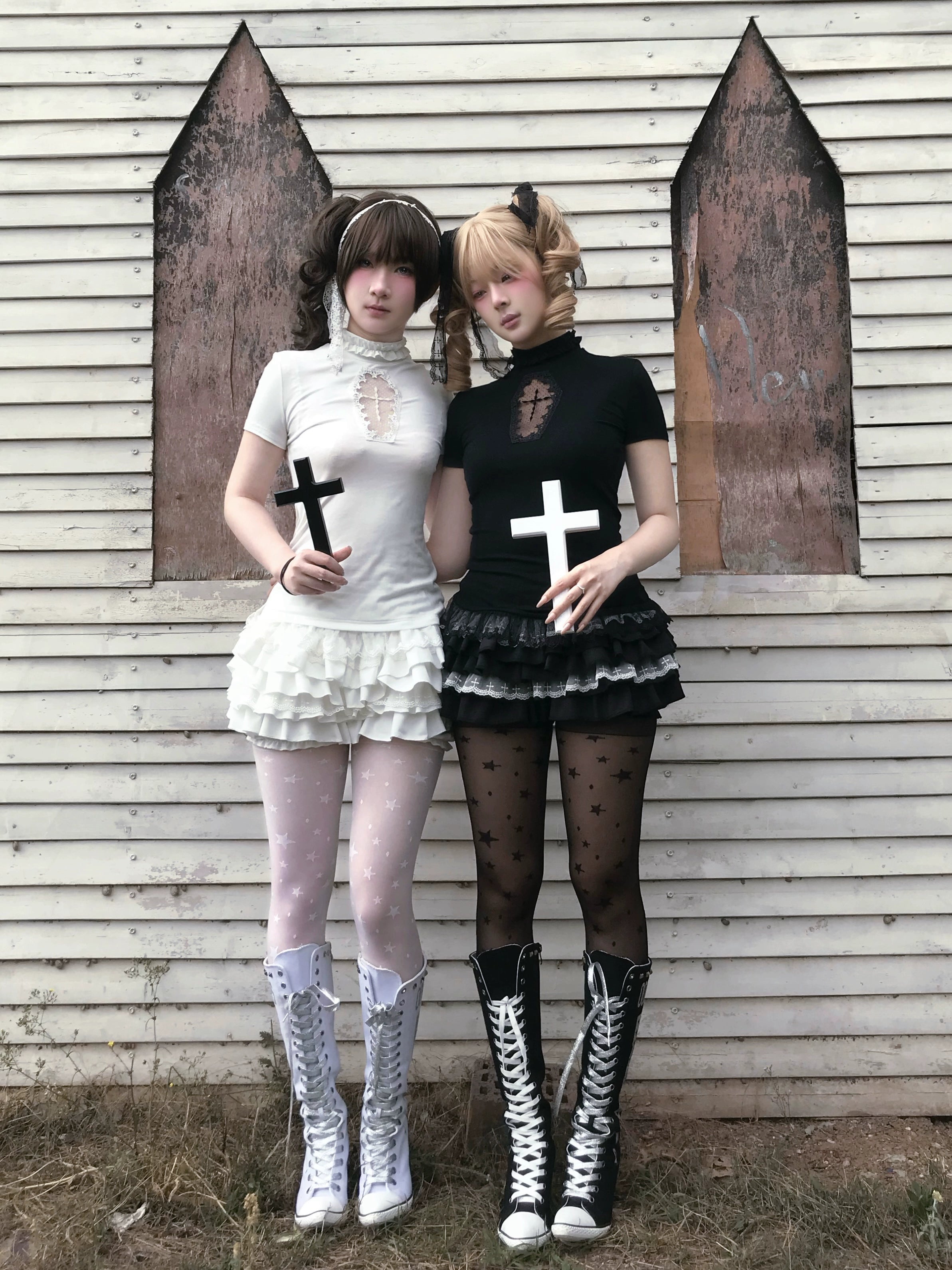 Two models in coordinated gothic cross-top and ruffle bloomers set with matching boots and accessories