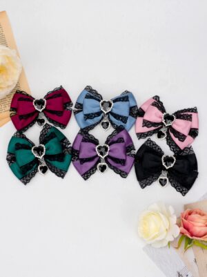 jirai kei butterfly knot bow hair clip color options arranged with artificial roses and vintage paper styling