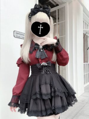 Jirai Kei long sleeve blouse with lace overlay worn by blonde model, wine red top with black ruffled cuffs paired with black layered lace skirt, front view