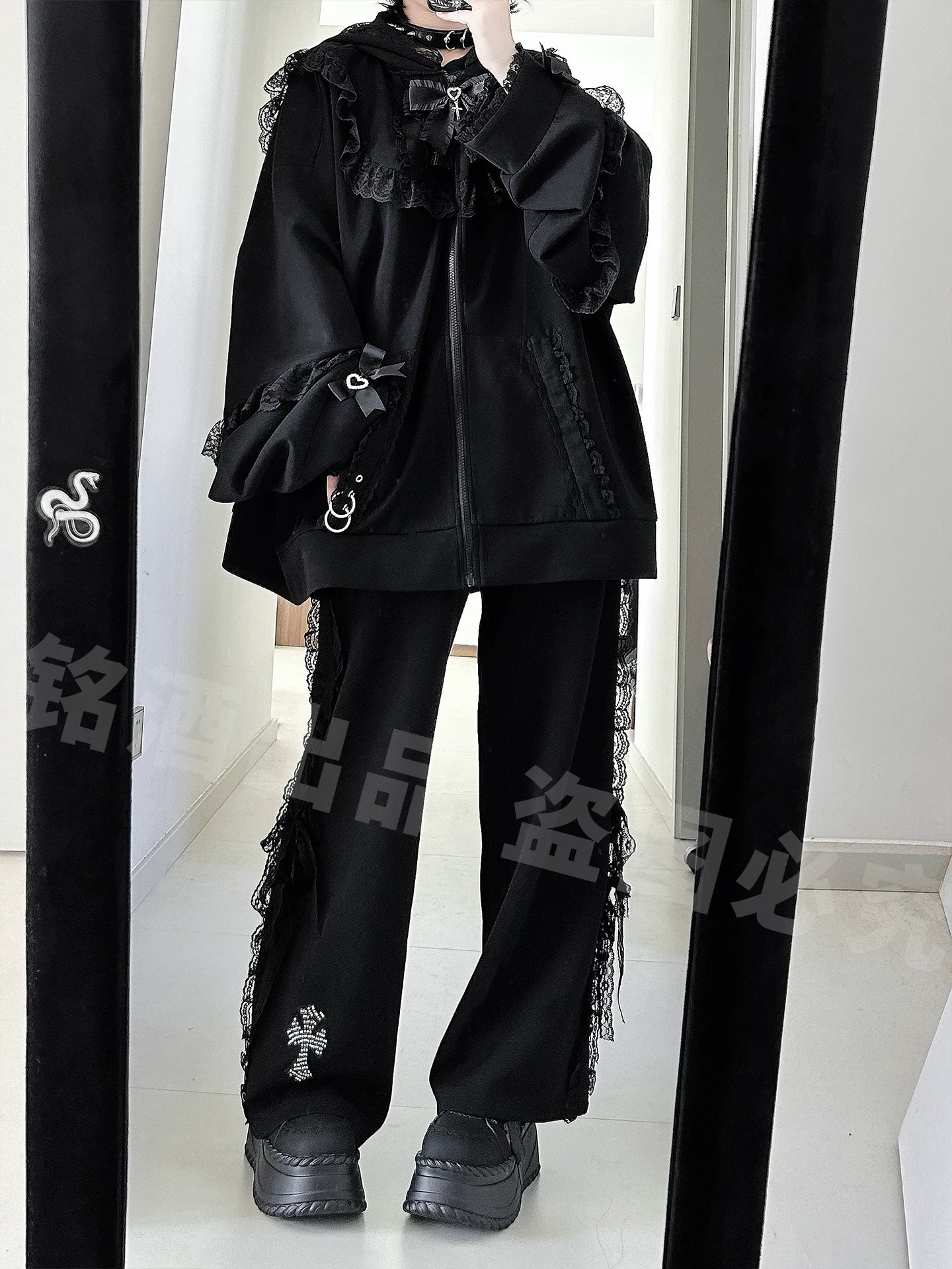 Black Jirai Kei zip-up hoodie and wide-leg pants set with lace side trims, cross embroidery details, and metal ring sleeve decorations, full-body side mirror selfie