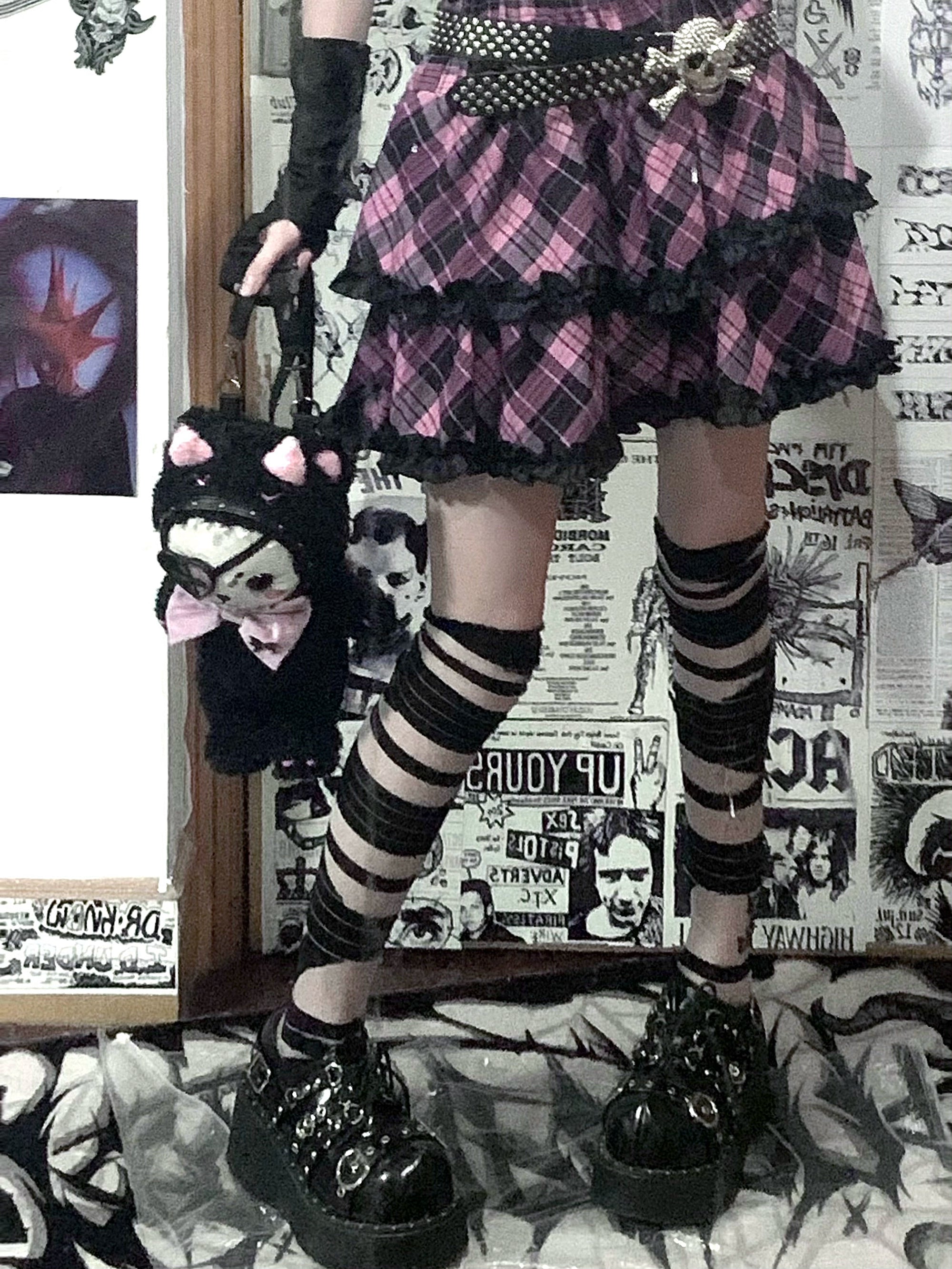 Pink-black plaid Jirai Kei ruffle skirt low-angle front close-up lower body, studded belt accessory, striped socks, skull cat handbag
