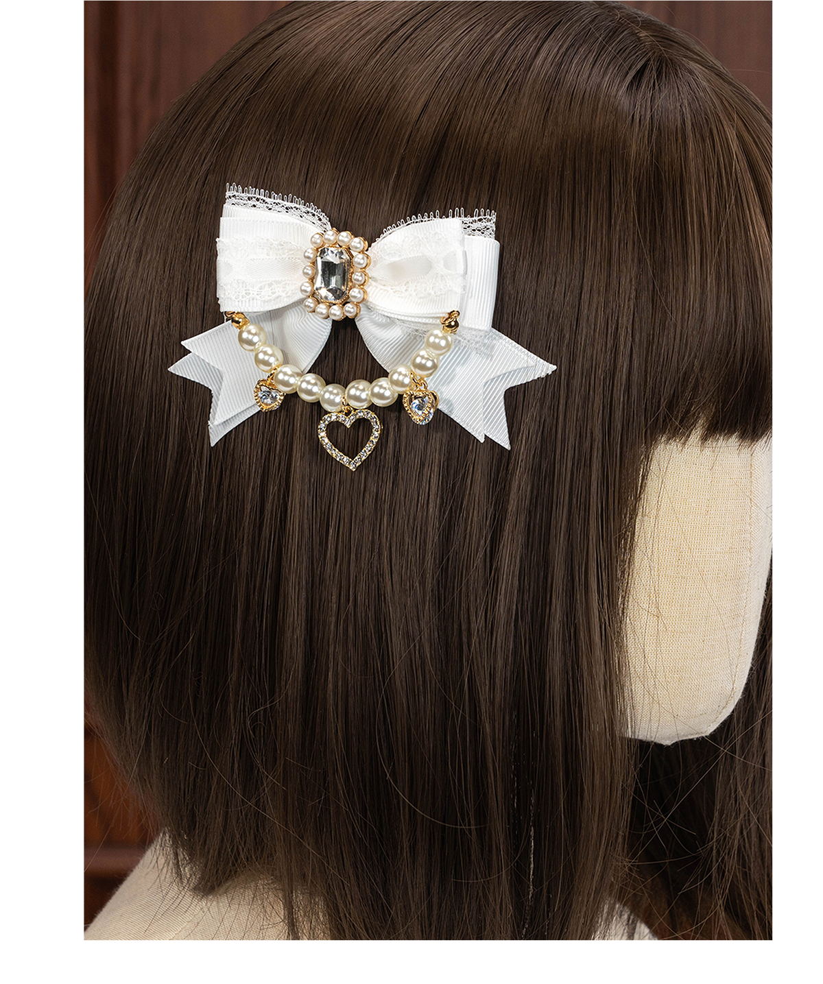 White delicate bow Jirai Kei hair clip with pearl chain and rhinestone accents displayed on mannequin head rear angle