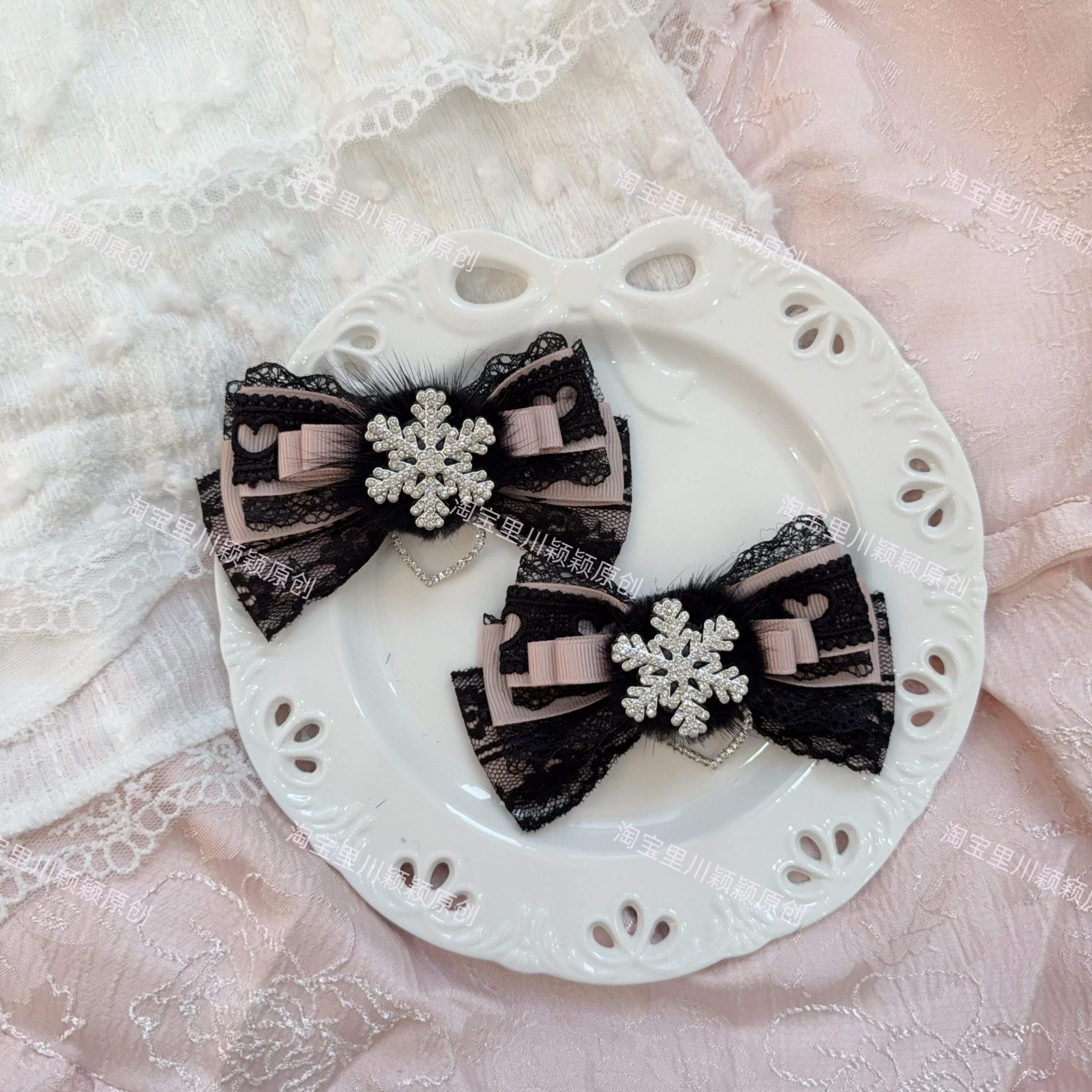Black and pink Jirai Kei bow hair clips with lace trim silver snowflake charm heart chain pendant on white plate pink lace background
