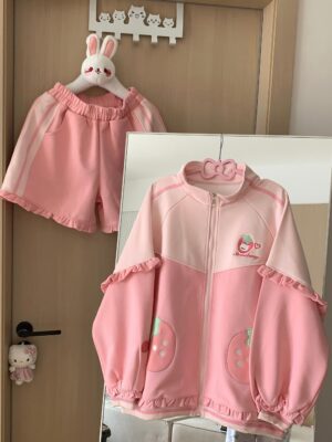 Pink strawberry Jirai Kei two-piece outfit flat lay display, featuring stand collar coat with ruffled edges and strawberry logo embroidery paired with coordinating shorts with bow and heart embroidery details