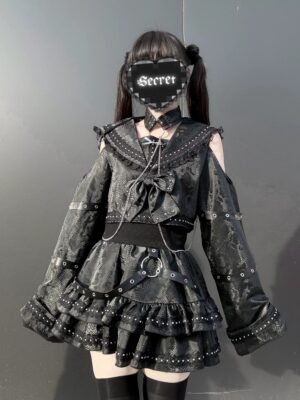 Jirai Kei gothic black sailor two-piece set front three-quarter view with cold-shoulder rivet-trimmed top and tiered ruffle skirt on model with twin-tail hairstyle