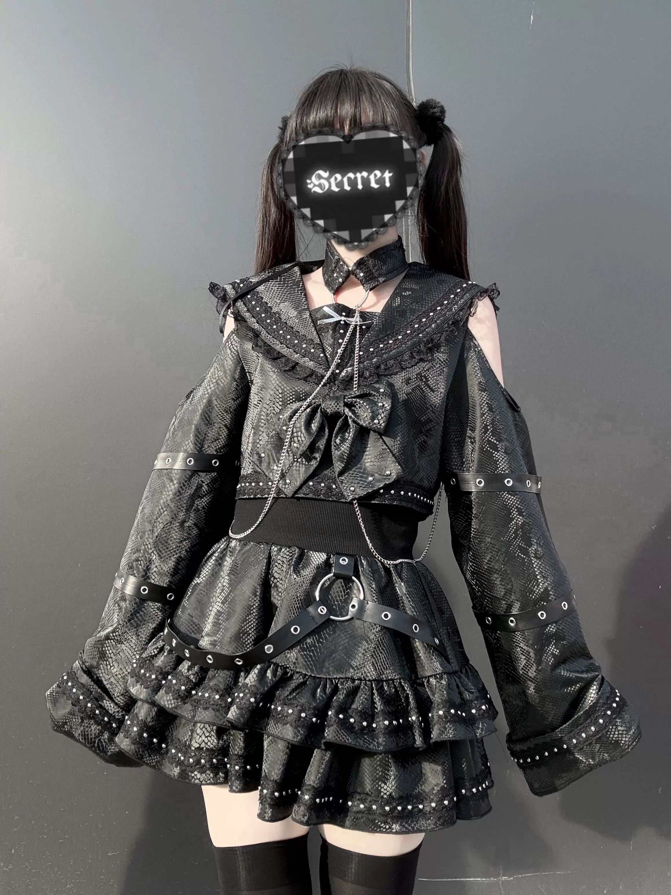 Jirai Kei gothic black sailor two-piece set front three-quarter view with cold-shoulder rivet-trimmed top and tiered ruffle skirt on model with twin-tail hairstyle