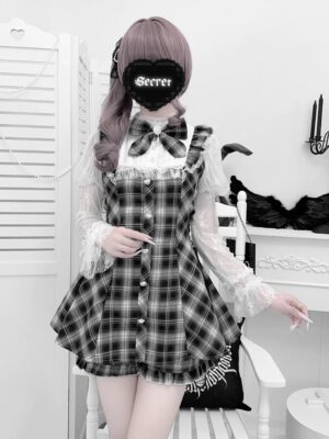 Full body front view of plaid Jirai Kei mini dress with sheer lace ruffled sleeves and detachable bow worn by masked female model against neutral backdrop