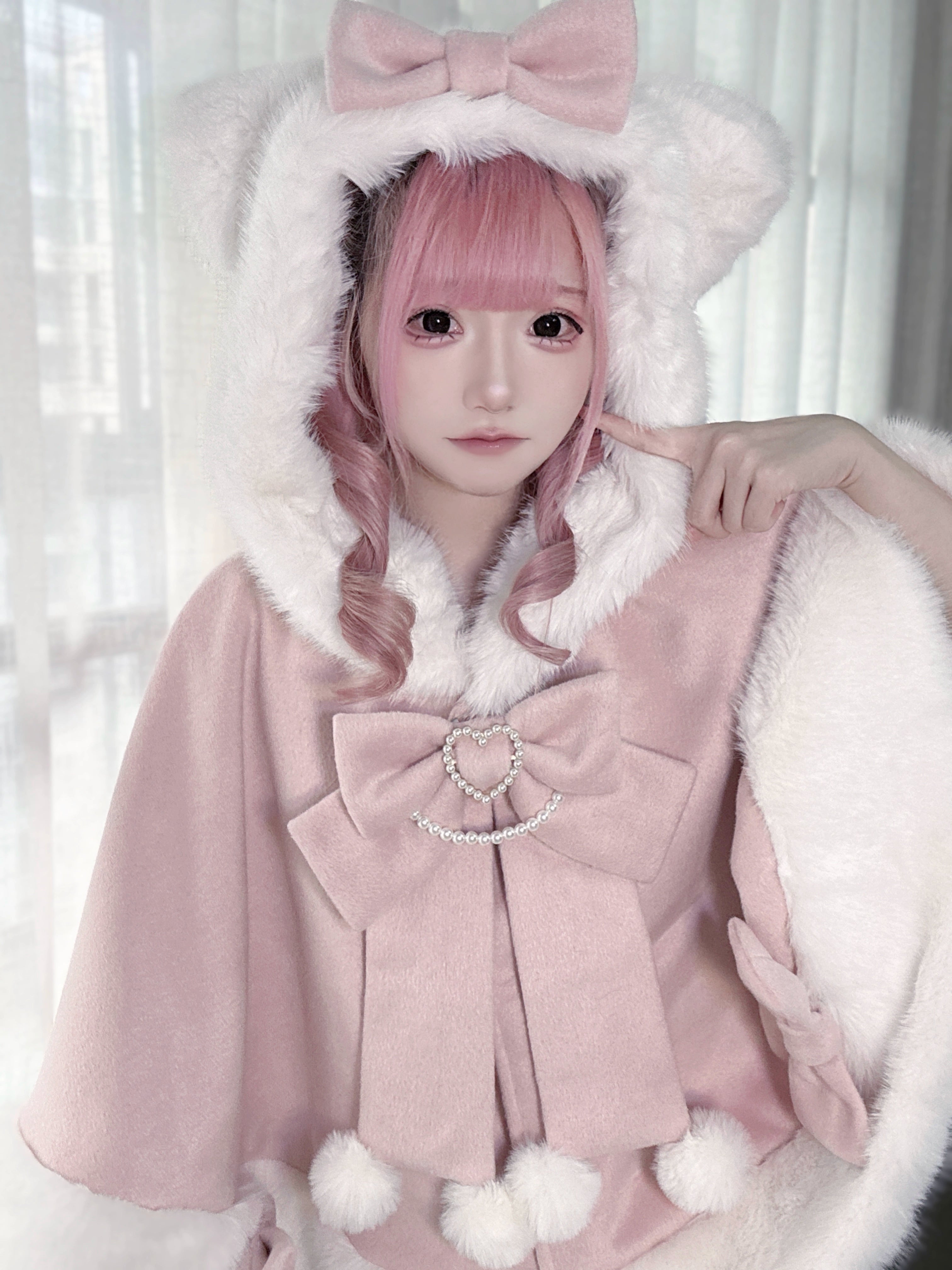Jirai Kei pink cat ear hooded plush cape worn by model with pink hair close-up portrait indoor window background
