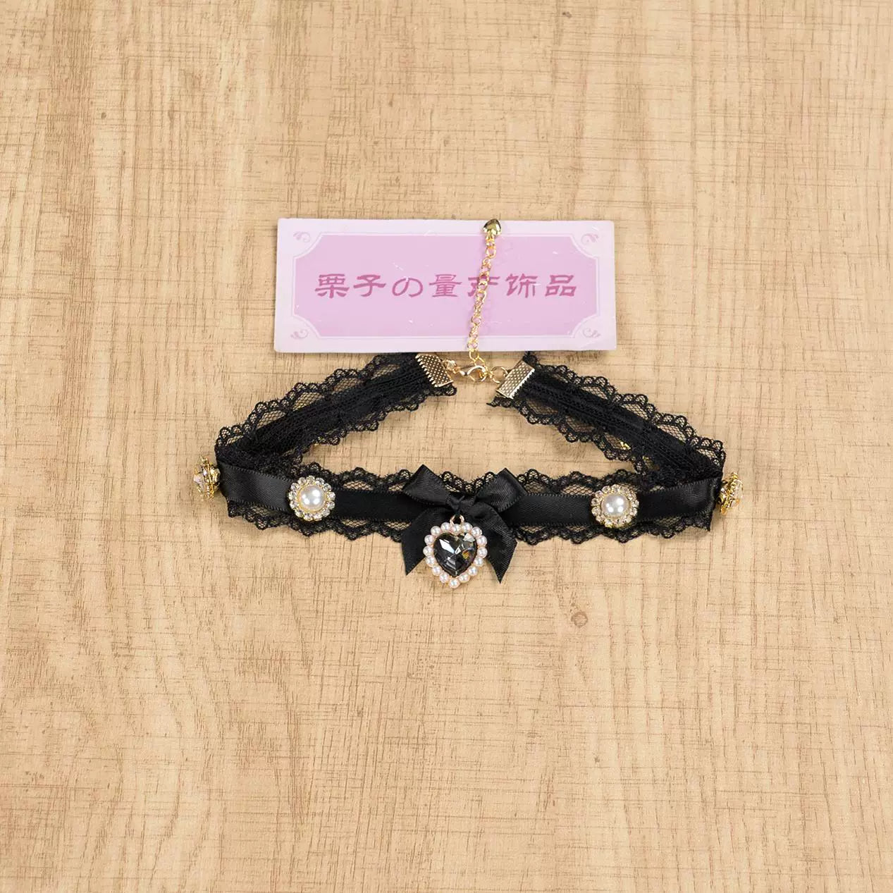 Pure black lace Jirai Kei choker necklace with black satin bow and heart rhinestone pendant detail shot