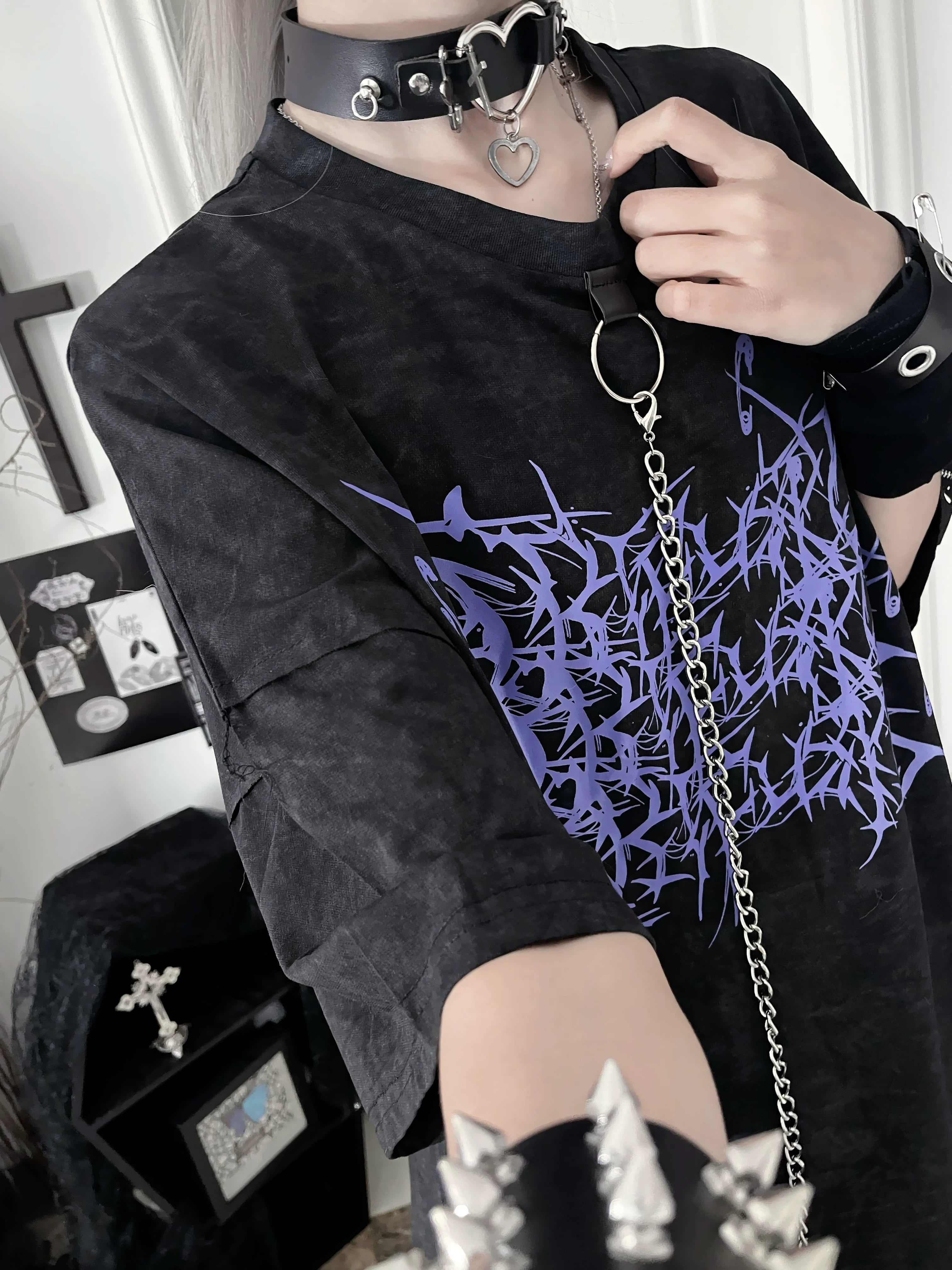 Neck-up close-up of black Jirai Kei t-shirt with purple thorn print, heart-shaped choker and metal ring chain detail