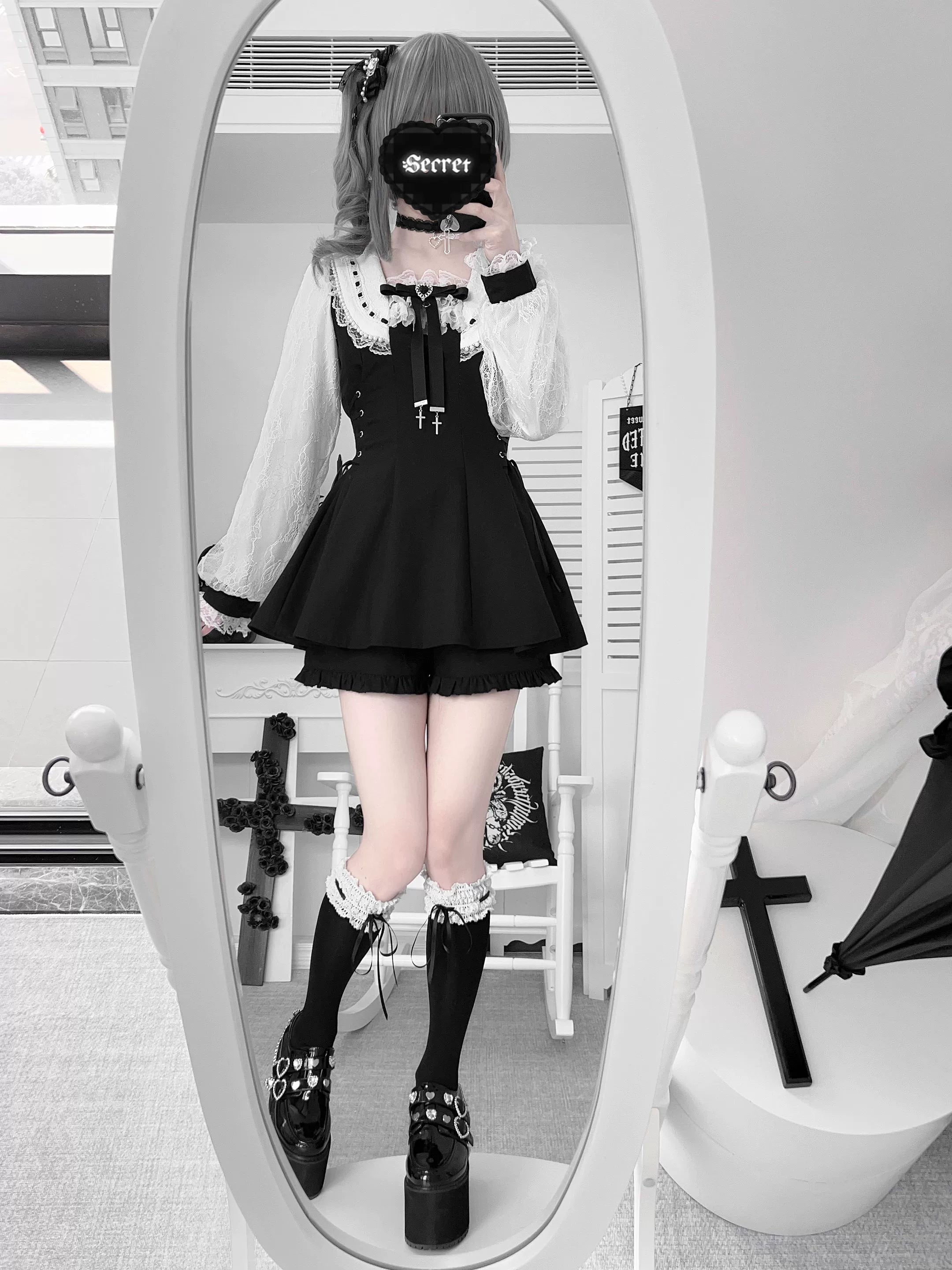 Model wearing solid black Jirai Kei dress set with cropped ruffled shorts, platform boots and ruffled socks in full-length mirror selfie gothic interior
