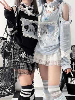 Jirai Kei cold shoulder blouse with lace patch and cute cartoon print front view two models side by side three-quarter angle showcasing water blue and black color options distressed punk aesthetic