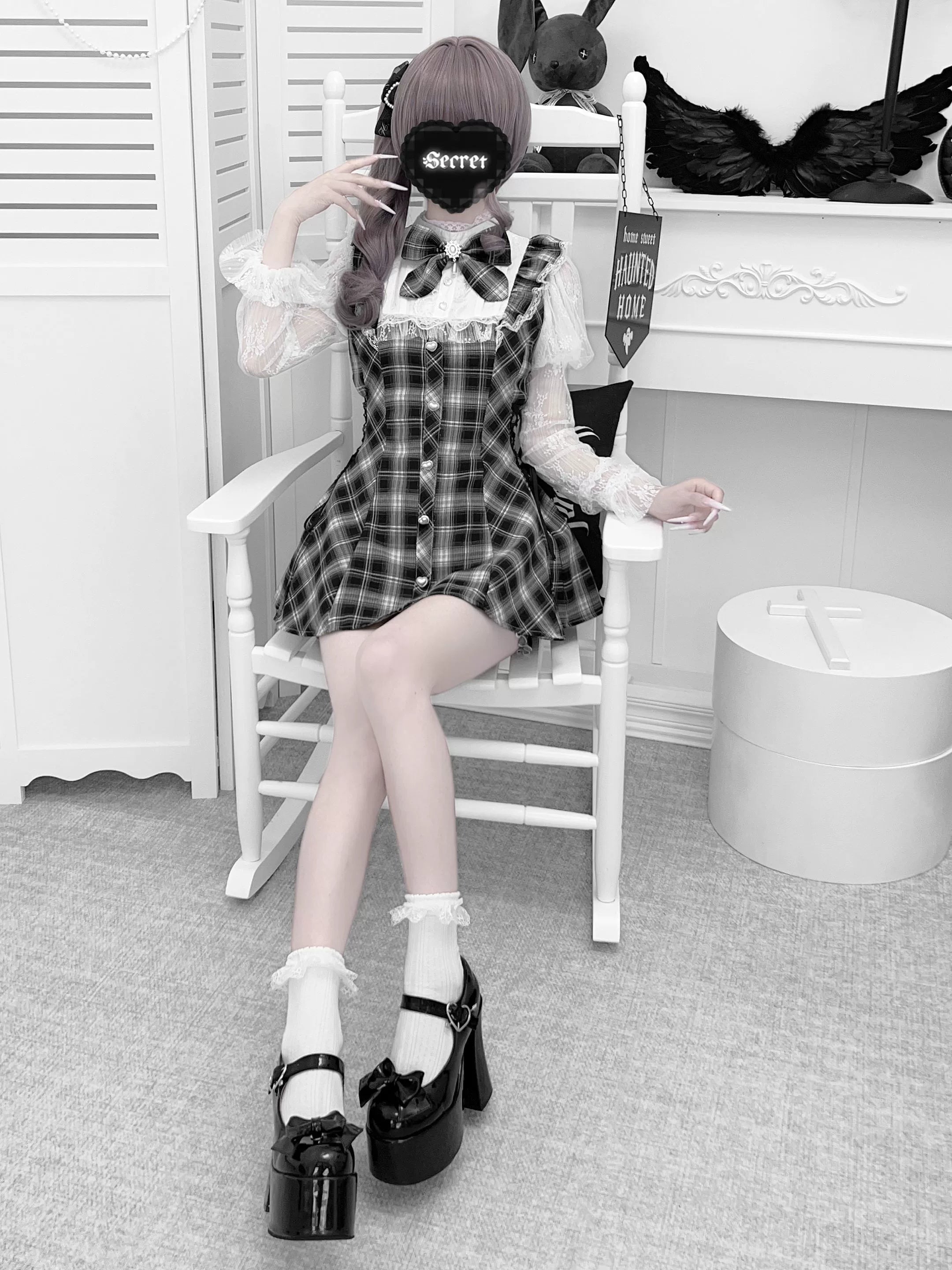 Seated full body view of plaid Jirai Kei dress with matching elastic shorts and detachable bow featuring white socks and platform heels on masked female model