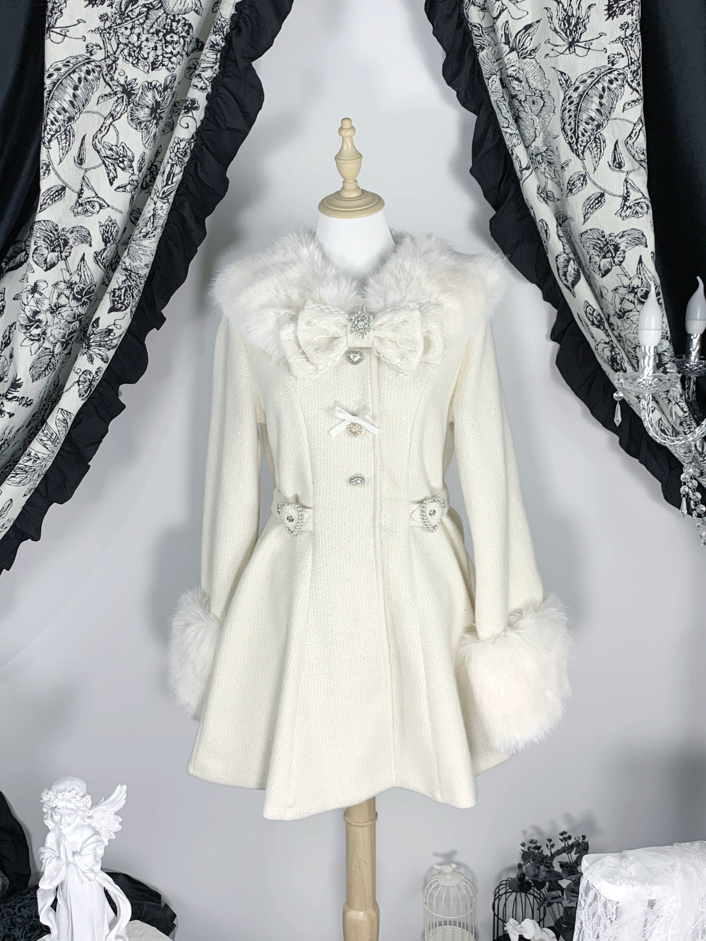 Beige Ryousangata winter coat flat front display on mannequin with faux fur collar cuffs and heart-shaped hardware details vintage curtain background