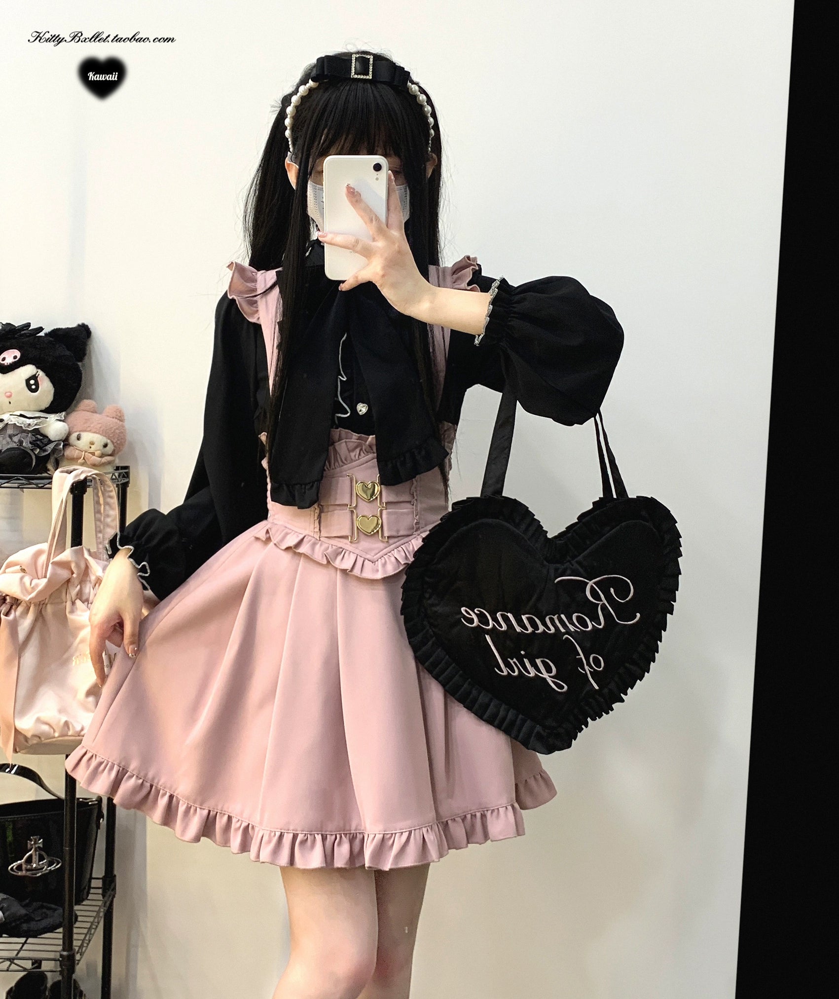 Pink ruffled Jirai Kei suspender skirt styled with black ruffled blouse black heart-shaped handbag and hairband accessory complete coordinate