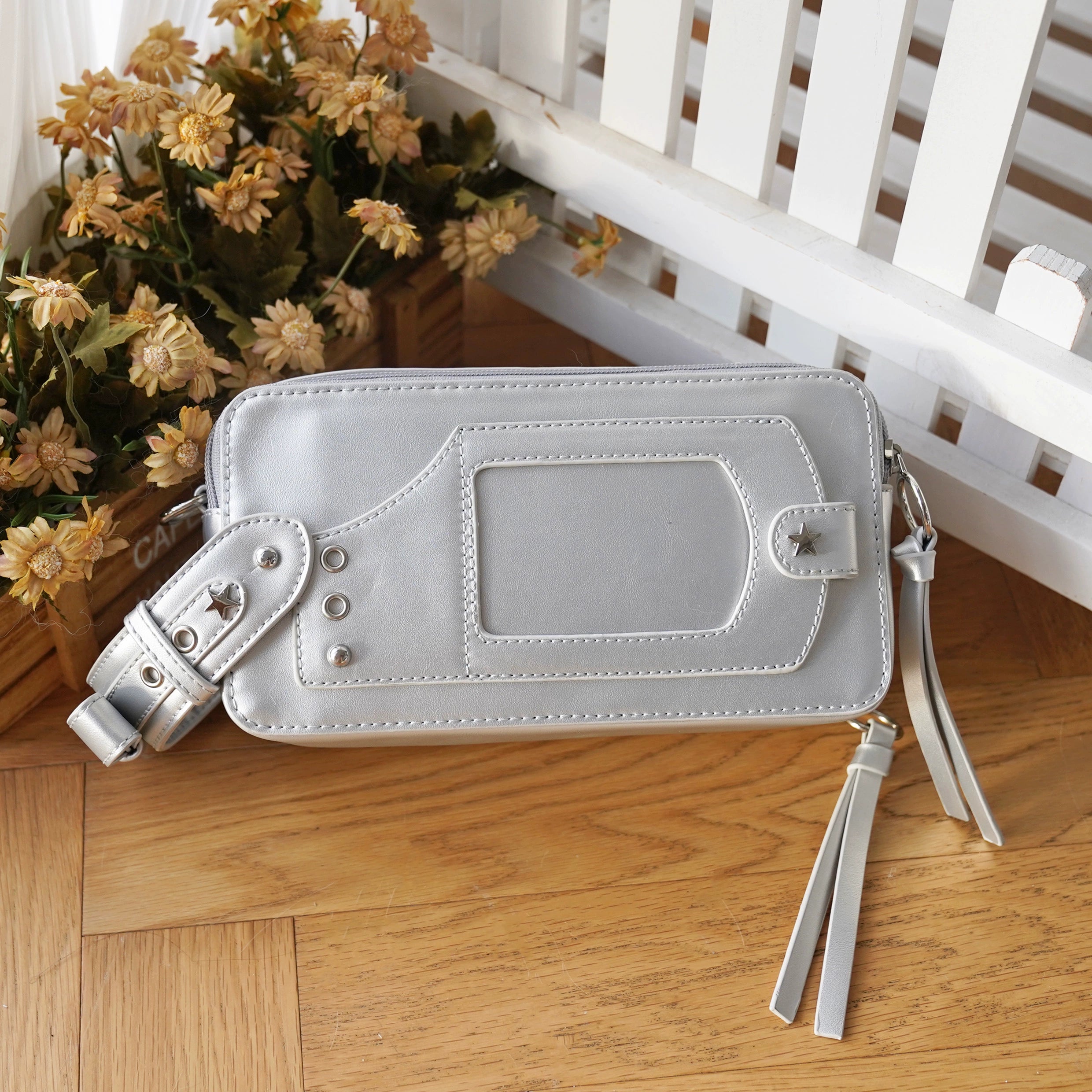 Grey silver jirai kei brick itabag side flat lay with back pocket tassel straps wooden floor floral decor