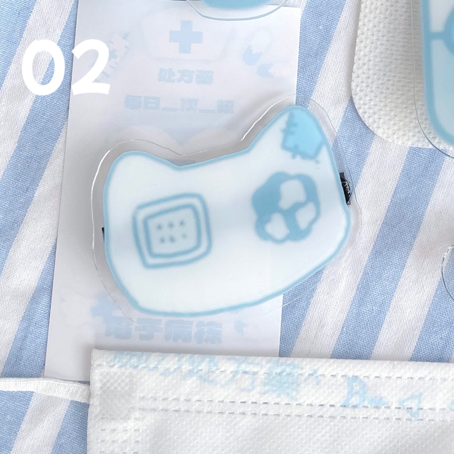 Cat mask shaped Jirai Kei acrylic hair clip with geometric skull and square patterns light blue design on blue-white striped fabric