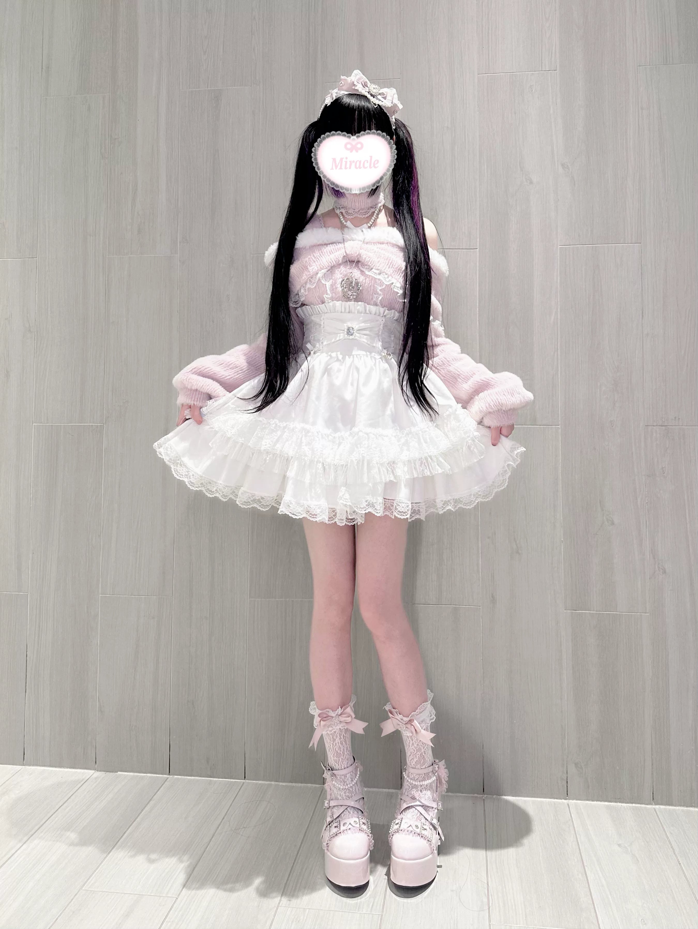 Back view of off-shoulder plush fleece top showing crisscross strap detail, ruffle construction, and loose sleeve design