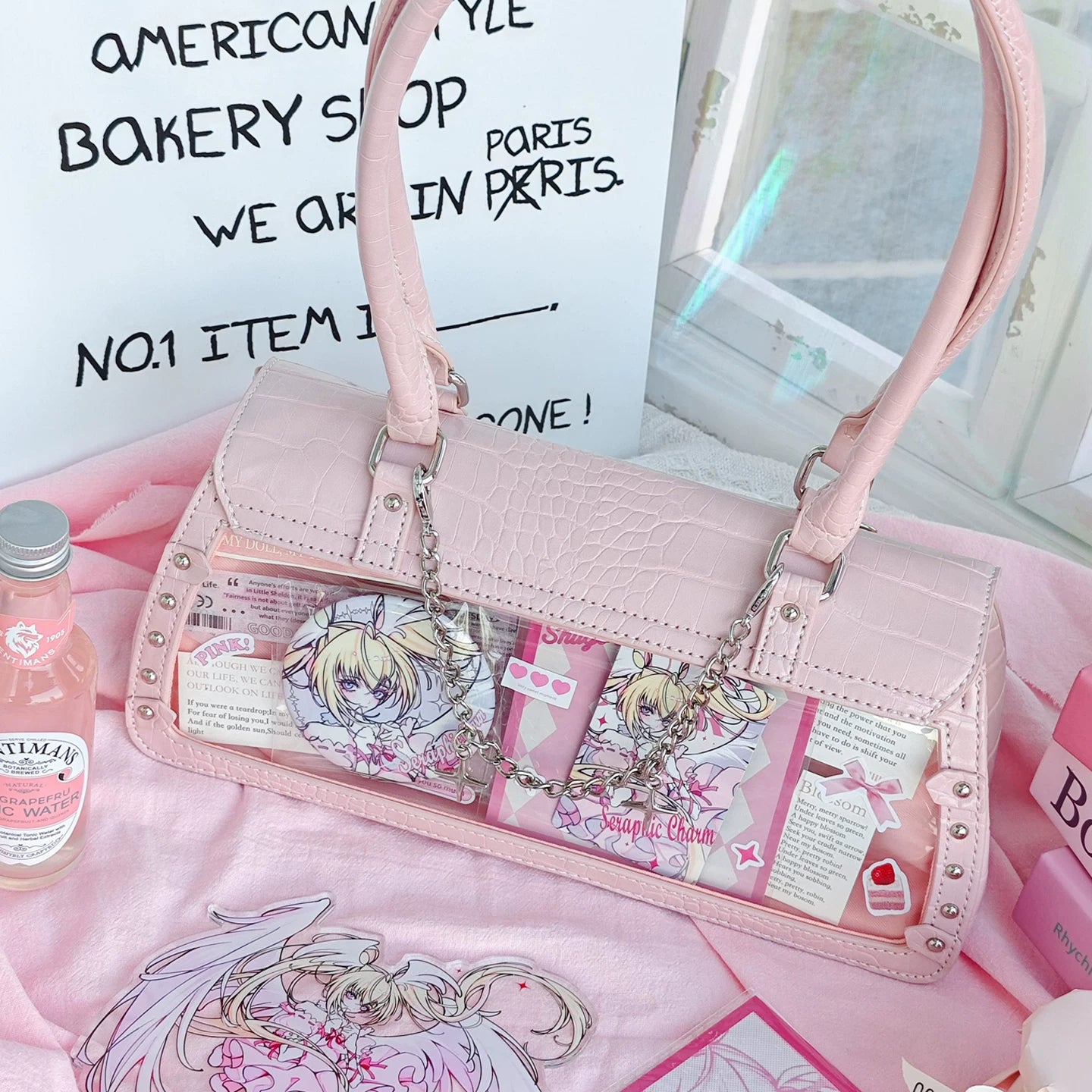 Bat-wing croc itabag clear display window filled with anime badge pins and character collectibles showing showcase potential for fans