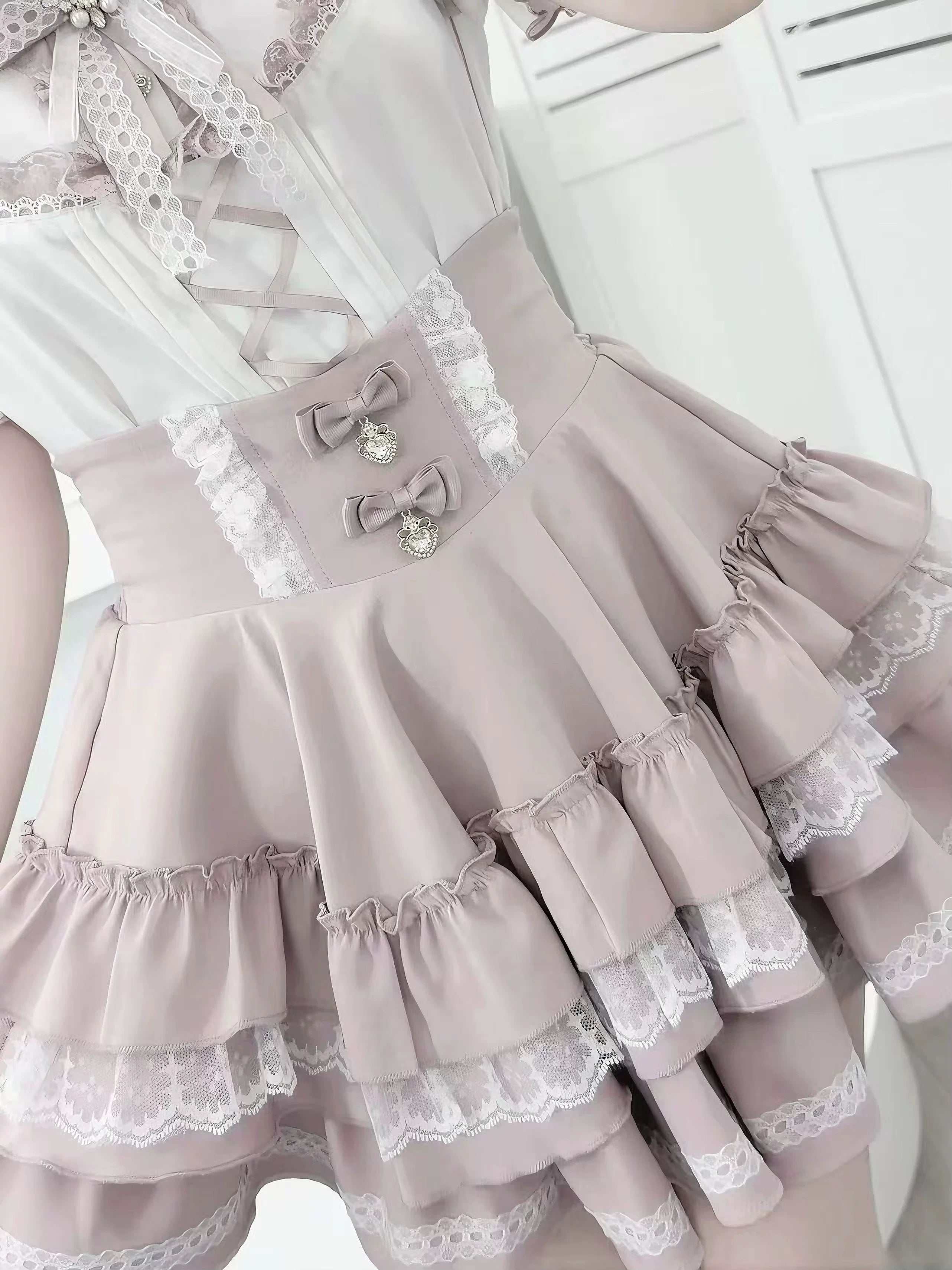 Pastel pink Jirai Kei tiered ruffle skirt full view displaying fabric texture layered construction and romantic silhouette