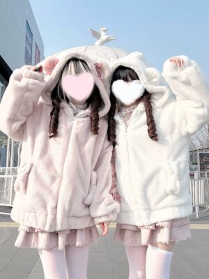 Two models in Ryousangata bear ear hooded fuzzy winter coats raising arms showing oversized fit and plush texture details