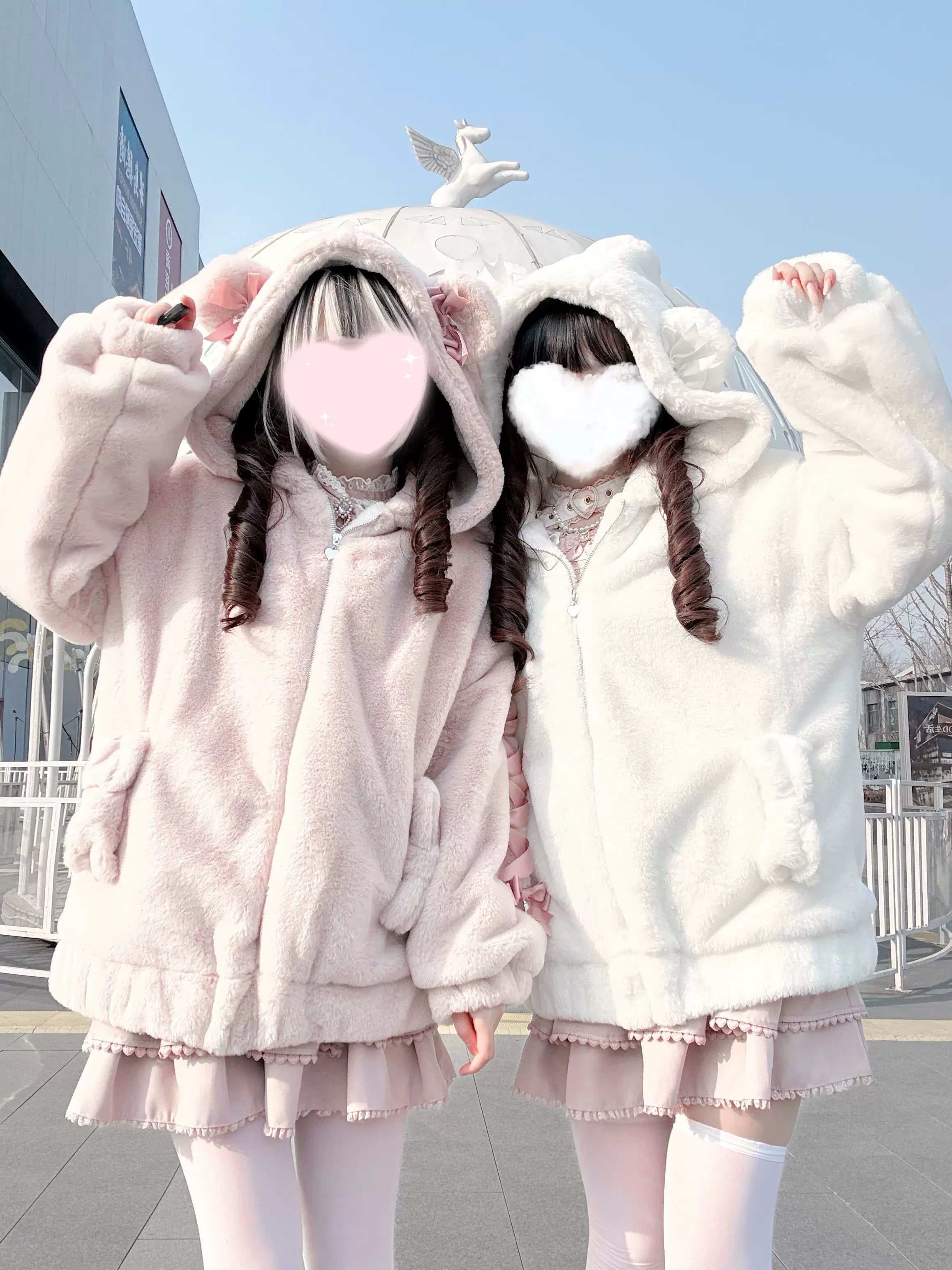Two models in Ryousangata bear ear hooded fuzzy winter coats raising arms showing oversized fit and plush texture details