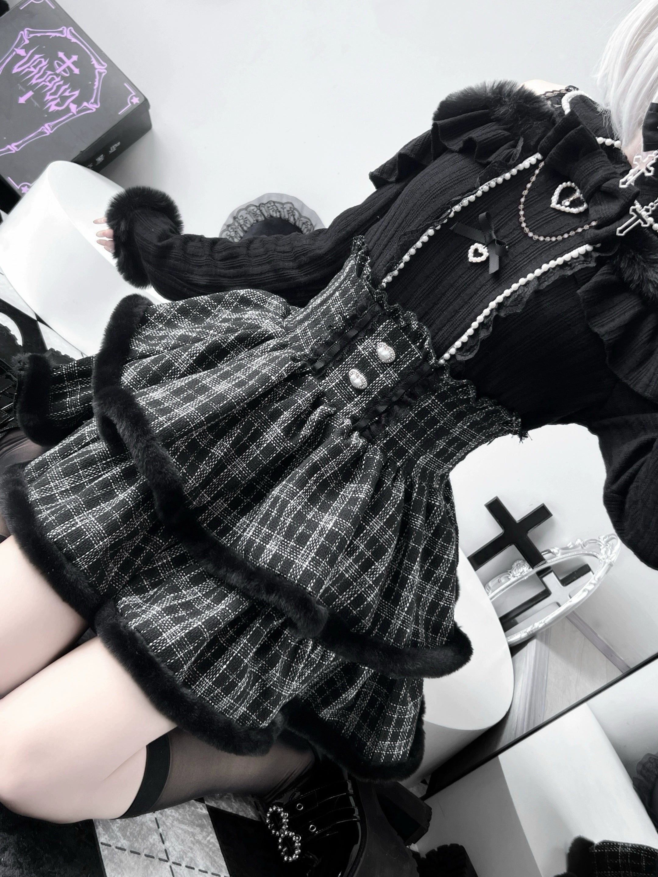 Overhead flat lay detail shot of Jirai Kei sweater showing lace trim, heart-shaped buckles, and plush collar construction on vanity background
