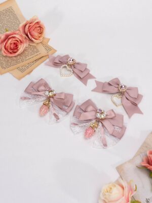 Mauve Jirai Kei lolita bow hair clips with lace strawberry charm and rhinestone heart decoration on white vintage background