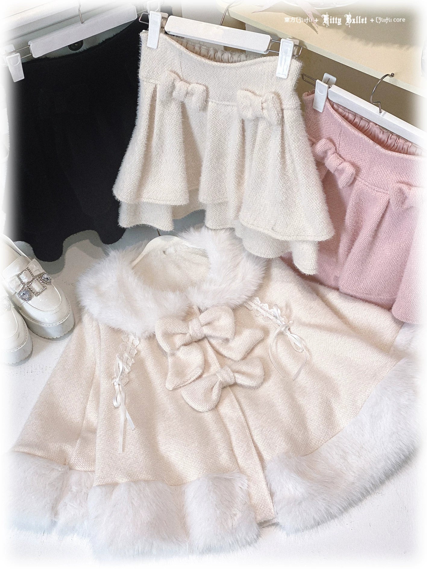 Beige Jirai Kei bunny ear winter cape on hanger display with fuzzy trims large removable bow decor and matching mini skirt ensemble