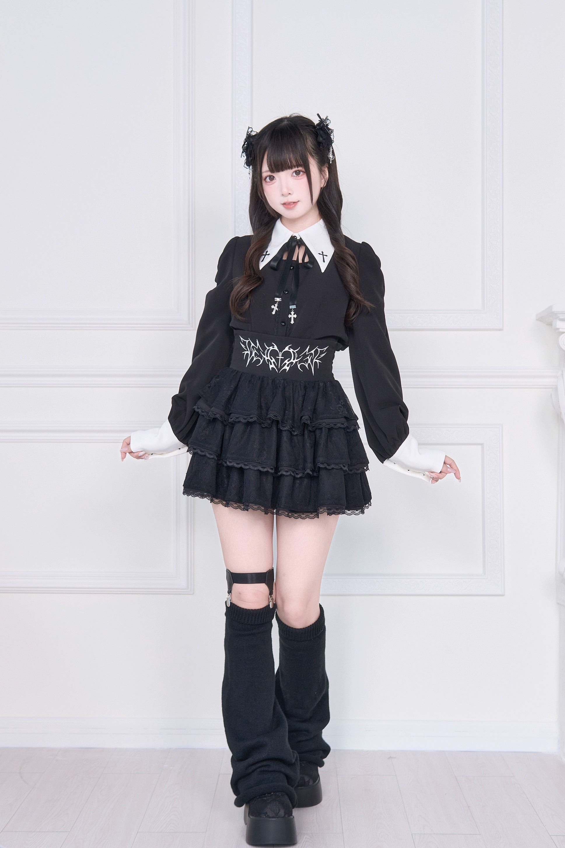 Jirai Kei outfit three-quarter front view black long-sleeve blouse white cuffs waist embroidery layered ruffles