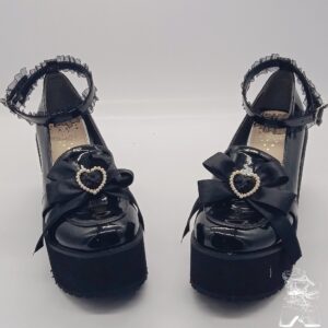 Black patent leather Jirai Kei platform shoes front view with lace ankle strap bow heart pearl ornament double shoe display