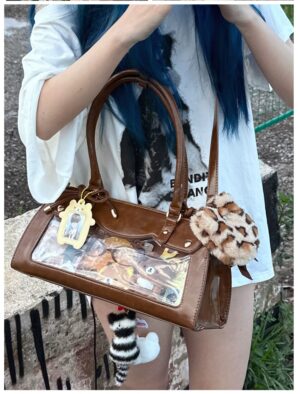 Brown leather baguette itabag with plush charm and anime card showcase, outdoor street low angle front view showing bag structure