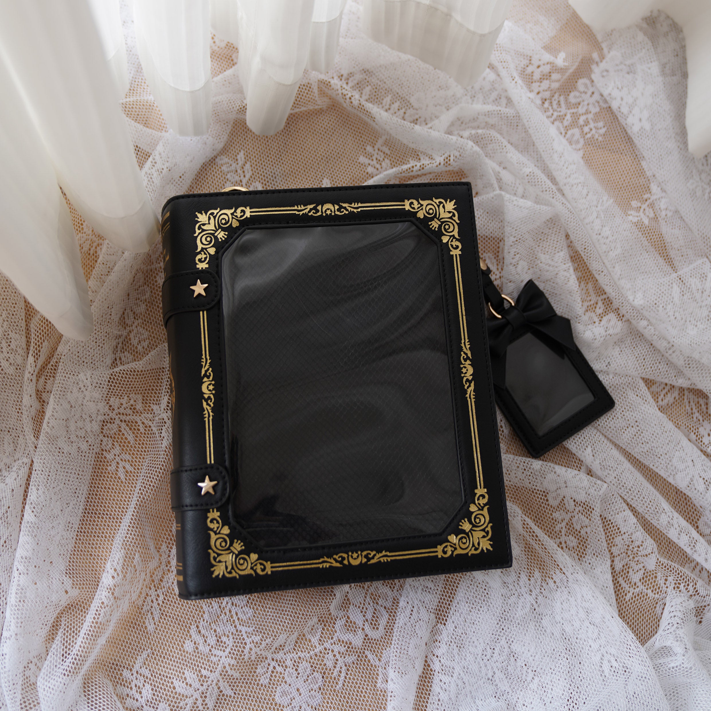 Black vintage grimoire Jirai Kei ita crossbody bag with gold antique border and star fasteners flat lay