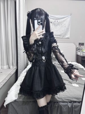 Black Jirai Kei ruffled mini skirt with sheer lace sleeves and heart-shaped chest decor, displayed in mirror selfie by twin-tailed goth model in bedroom setting