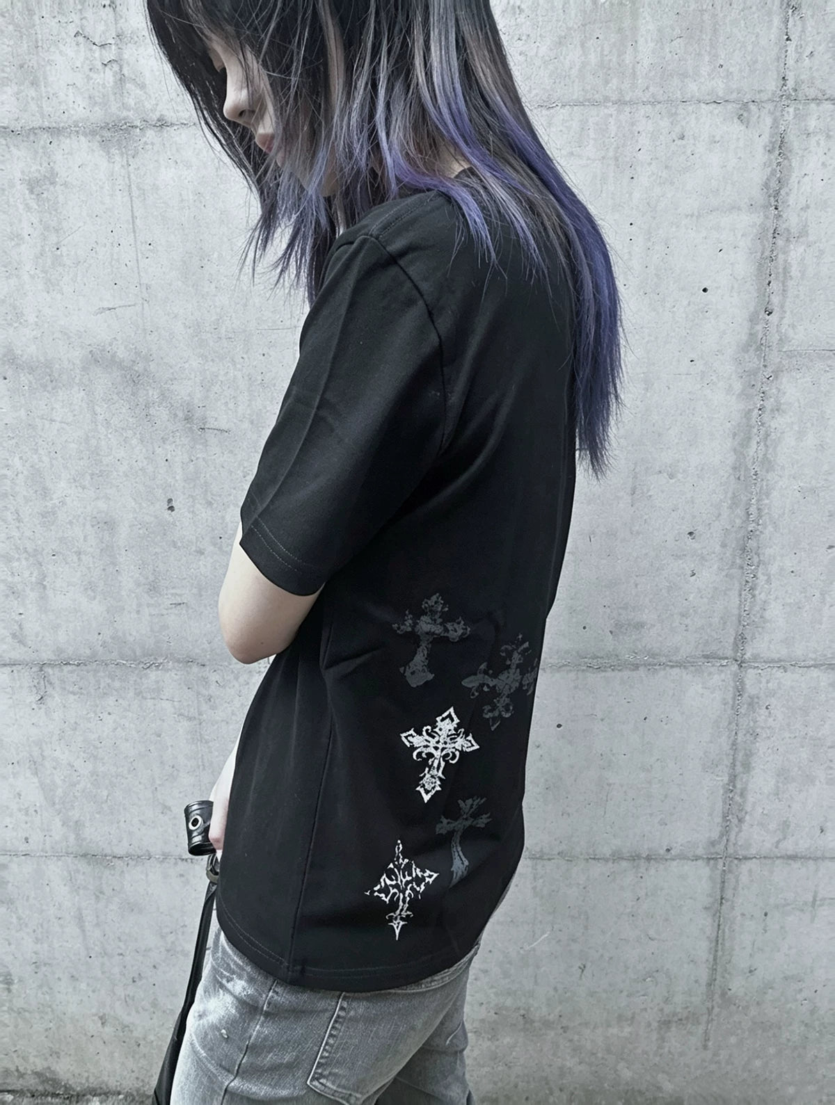 Black gothic cross print t-shirt side profile view, demonstrating staggered cross placement and fit silhouette, dark alternative fashion aesthetic