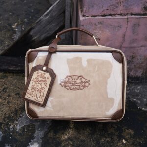 Vintage square itabag top front flat lay view outdoor concrete background two-tone beige brown leather structure branded metal badge luggage tag