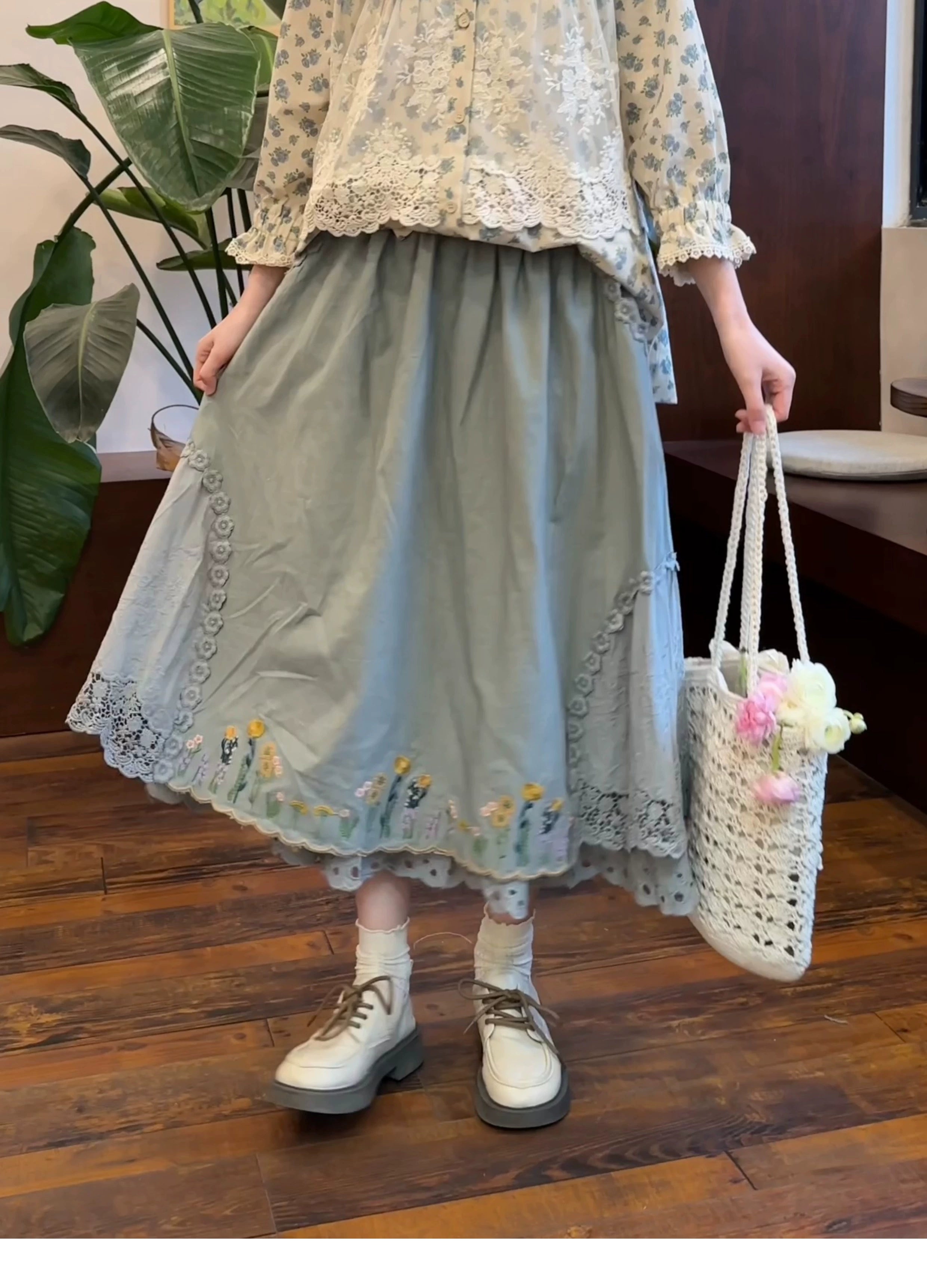 Mori kei embroidered linen long skirt dusty blue color with floral embroidery and crocheted lace hem front partial body view