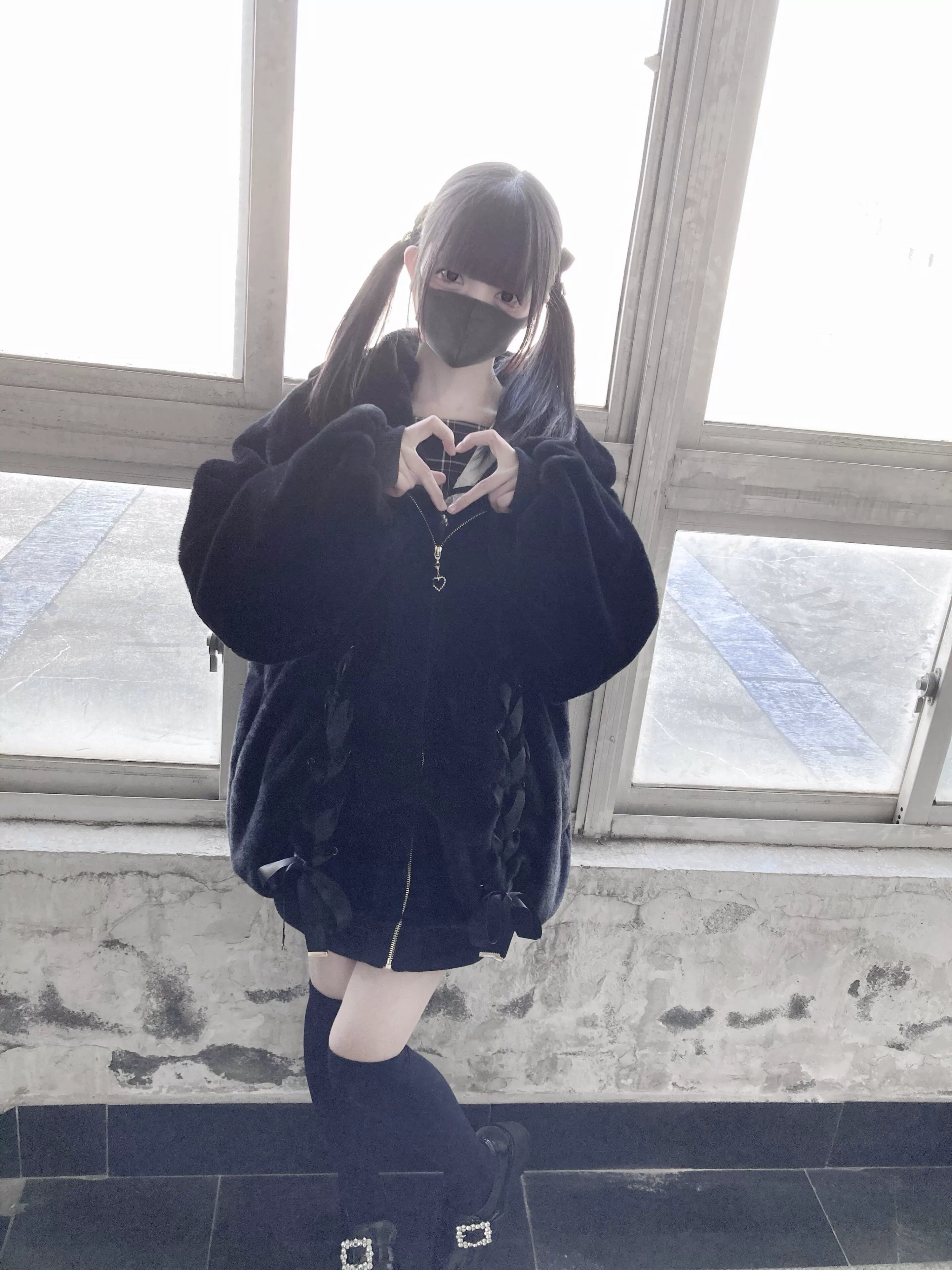 Black plush fleece coat front medium view with heart-shaped zipper detail and lace-up ribbon embellishments