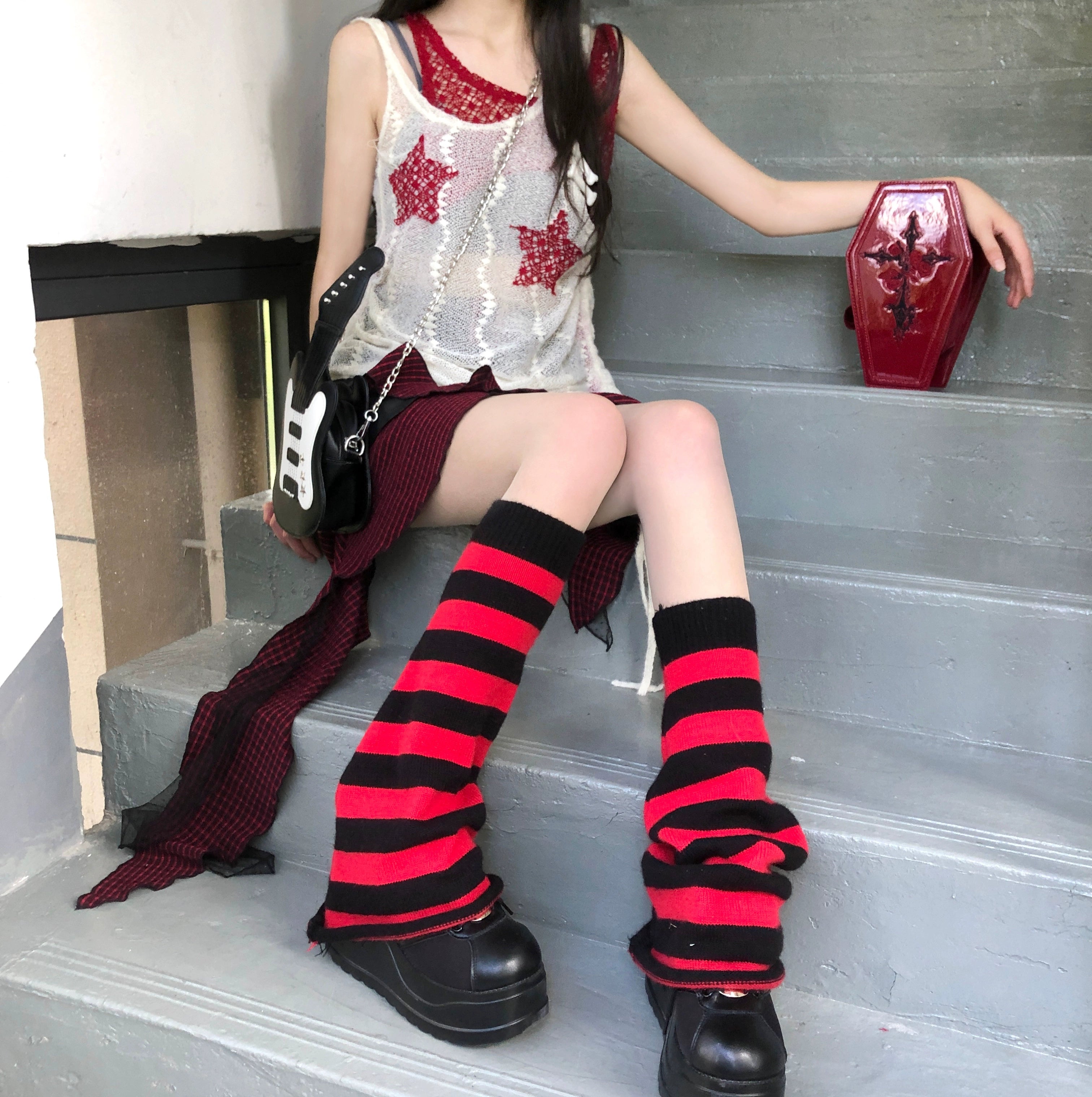 Red and black horizontal striped Y2K leg warmers with slouchy knitted texture front view worn with camisole top staircase setting