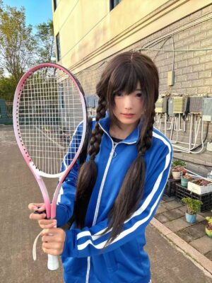 Royal blue Jirai Kei track jacket with white sleeve stripes worn by model with twin braids outdoor paved setting front view
