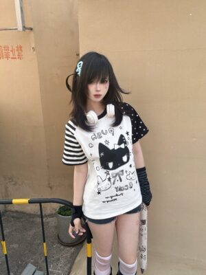 Jirai Kei cute cat print cotton t-shirt black and white kawaii style front three-quarter view outdoor rooftop with female model split contrast sleeves cartoon cat graphic text design