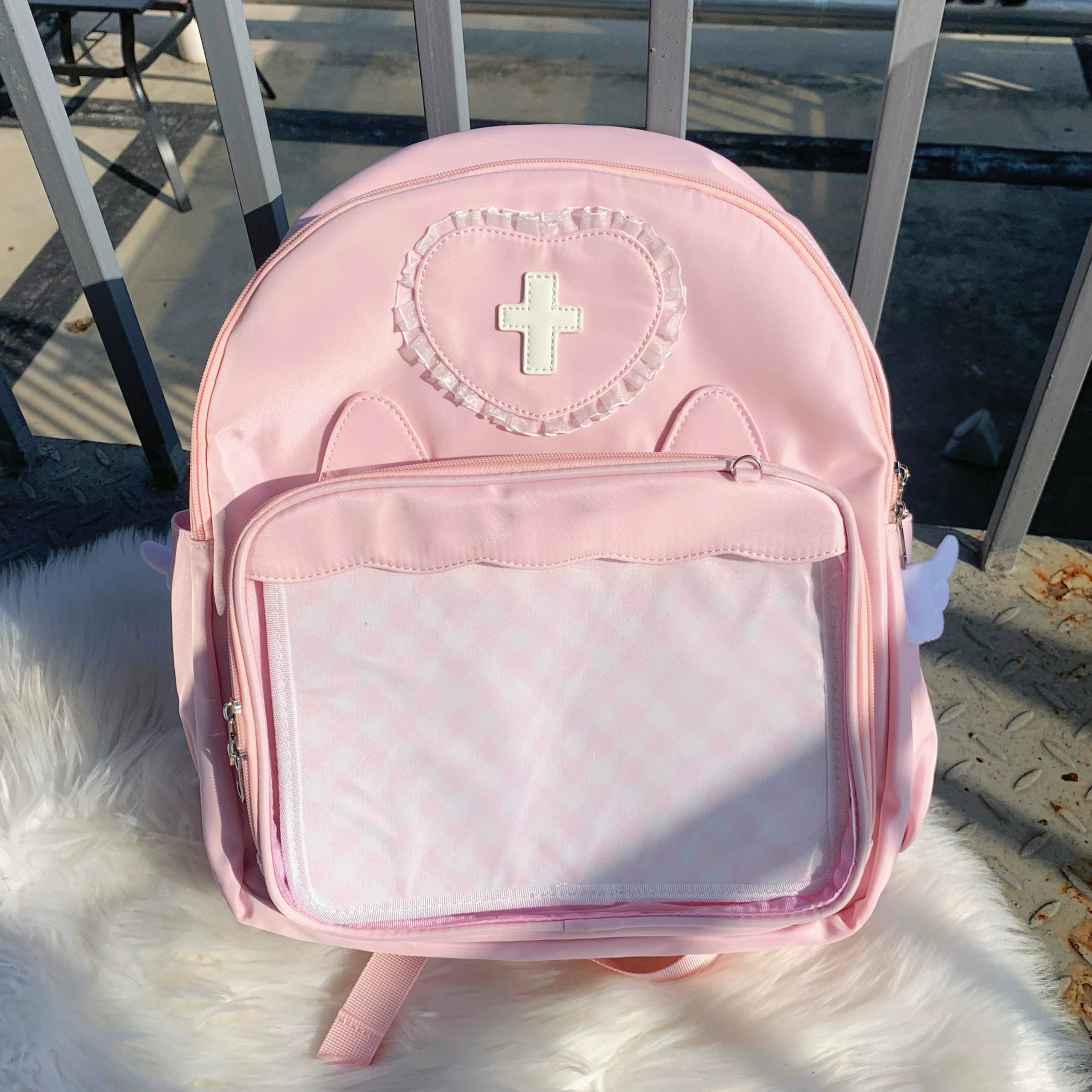 Pink L-size Jirai Kei itabag backpack spacious collection showcase with heart-shaped lace cross badge, large transparent display window and angel wing side details