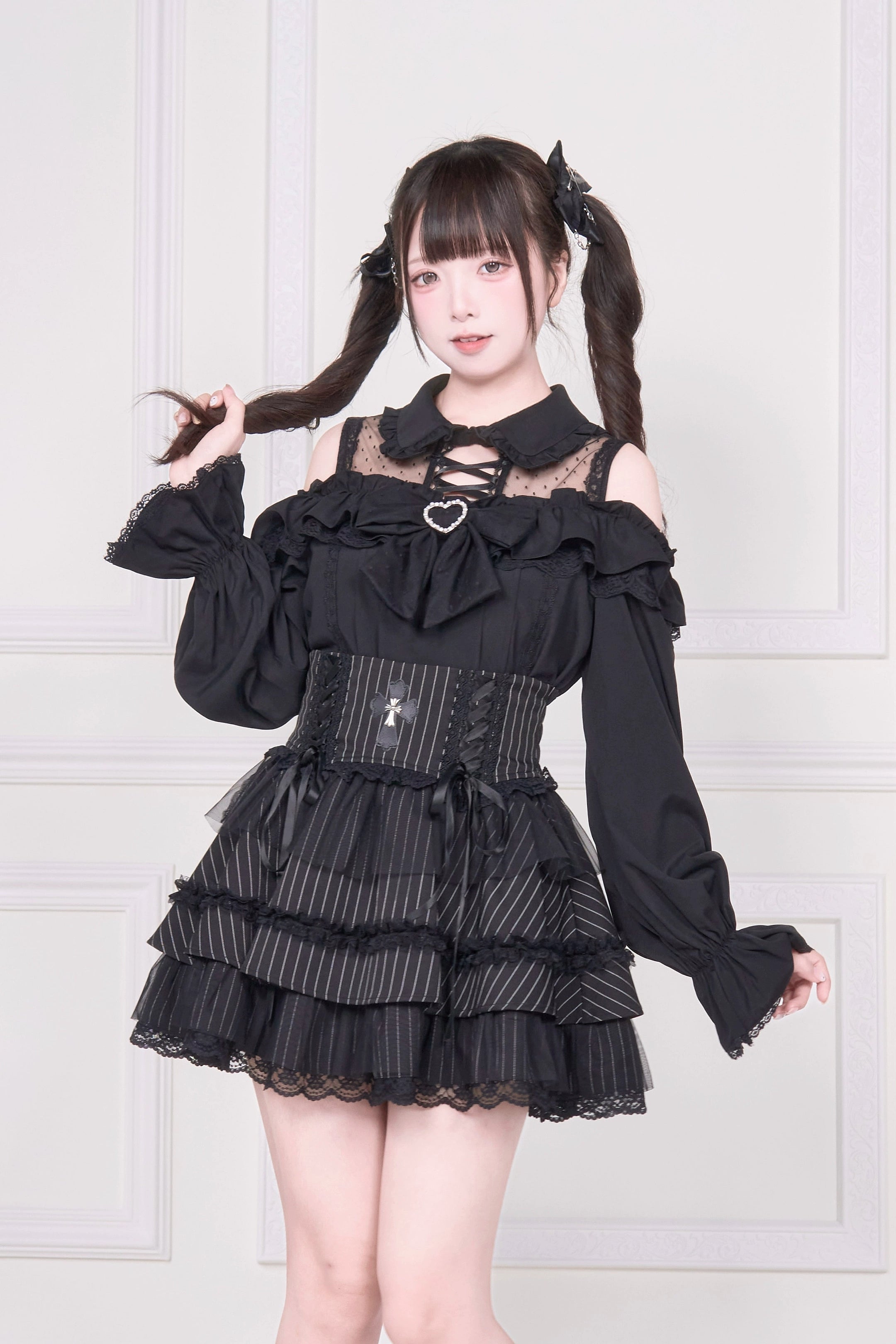 Black cold-shoulder Jirai Kei blouse with lace-up detailing and ruffle skirt three-quarter front view on model