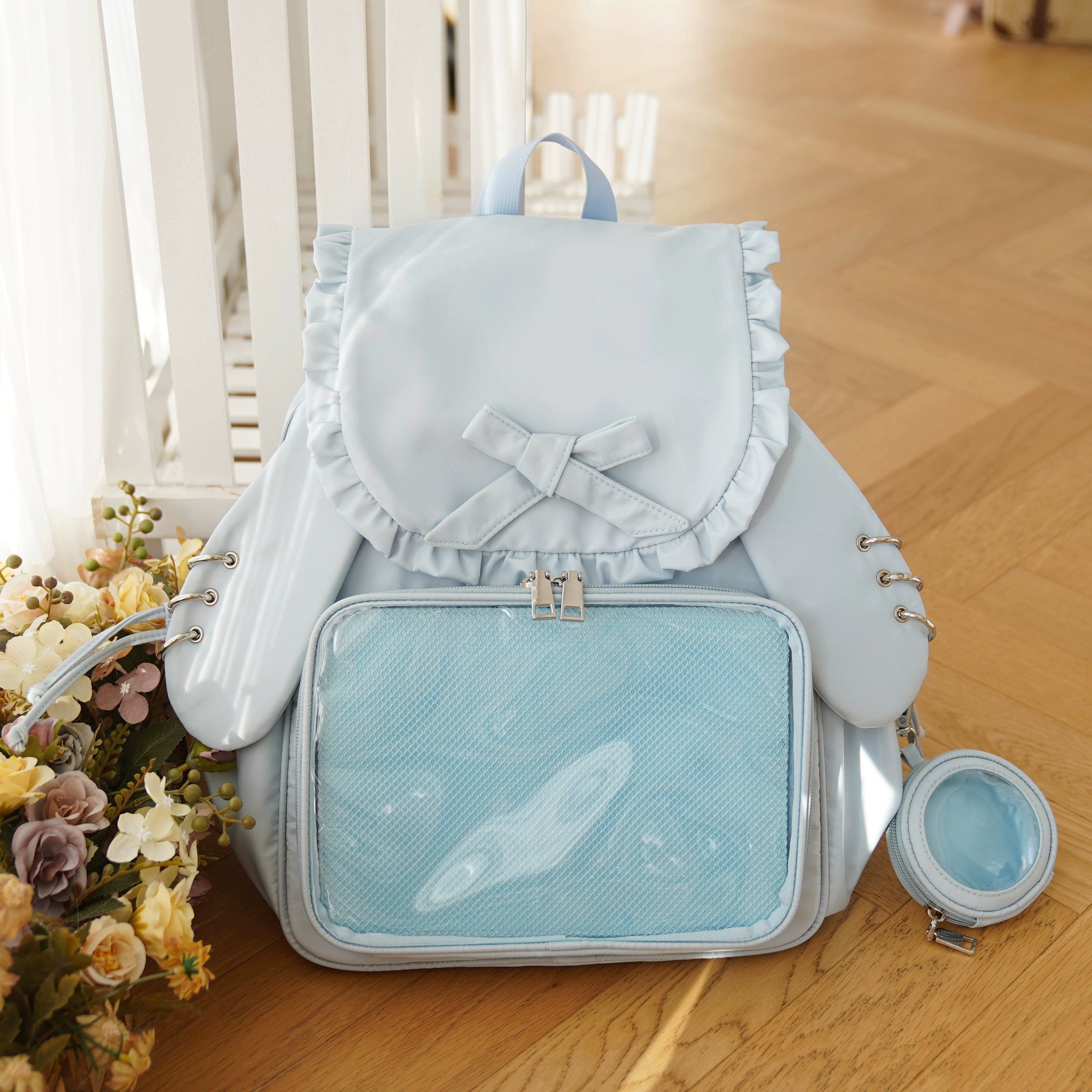 Blue Jirai Kei kawaii itabag backpack with bunny ear design, transparent collectible display panel, ruffled bow decoration, and blue pouch accessory
