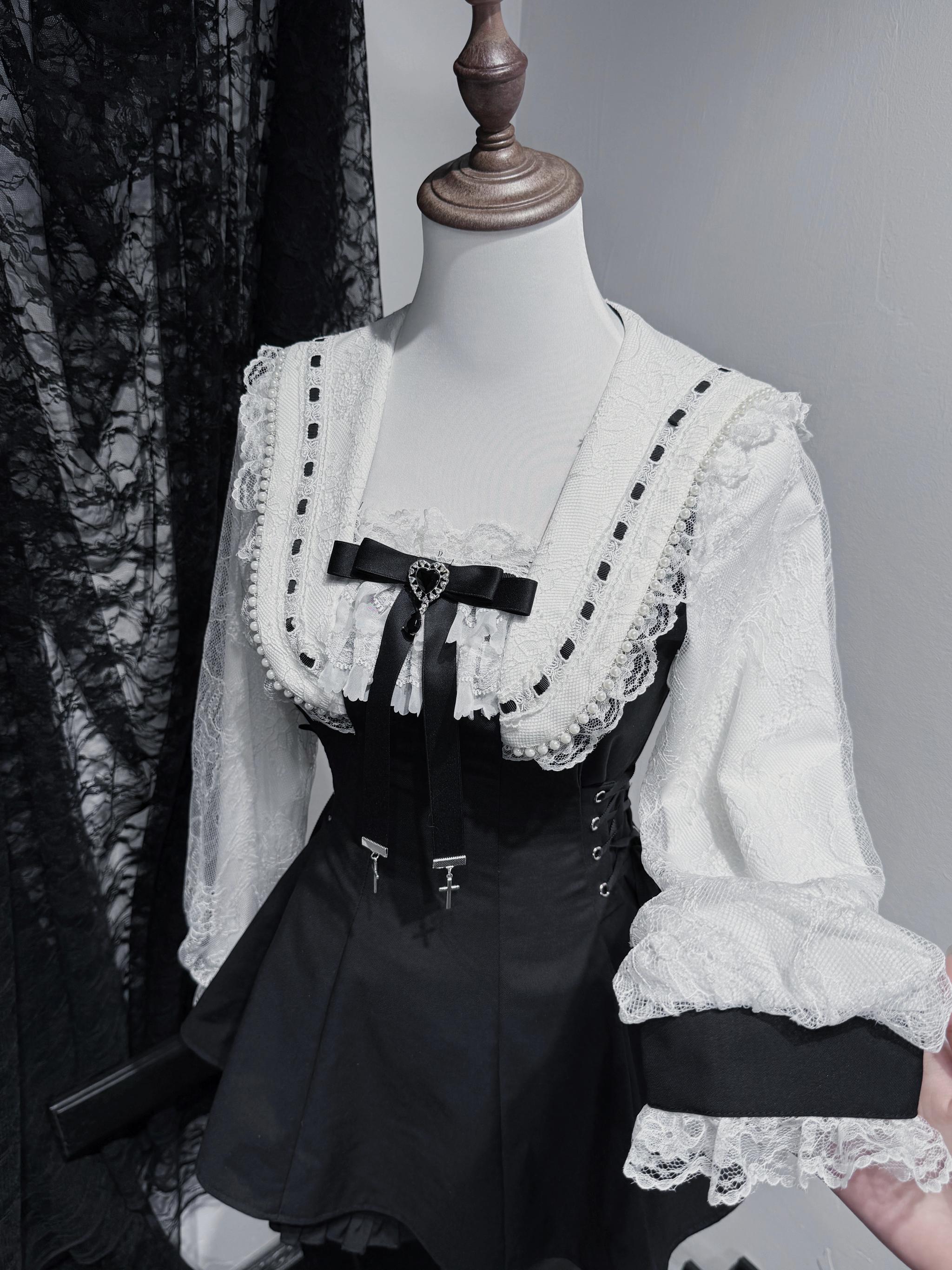 Close-up mannequin display of solid black Jirai Kei dress set highlighting heart bow tie corset lace-up waist and ruffled blouse cuffs