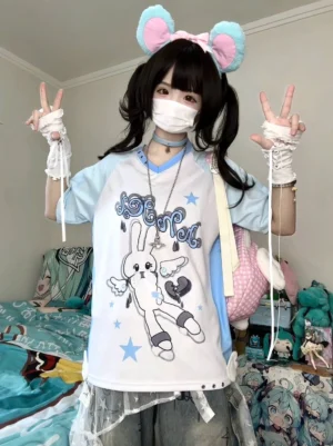 Angel Bunny Tenshi raglan T-shirt front full-body view featuring light blue sleeves, adorable bunny print with angel wings and star motifs, worn by twin-tail model in anime-themed bedroom setting