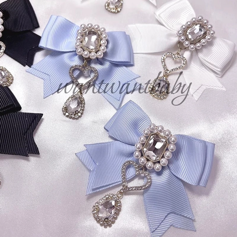 Assorted multi-color Jirai Kei pearl rhinestone bow hair clips loose flat lay arrangement showing complete color palette with dangling charms