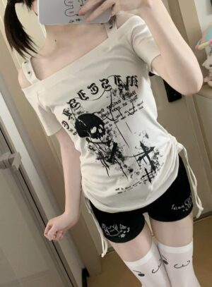 Beige cream off-shoulder skull graphic Jirai Kei t-shirt with asymmetrical strap and side drawstring, indoor home doorway perspective